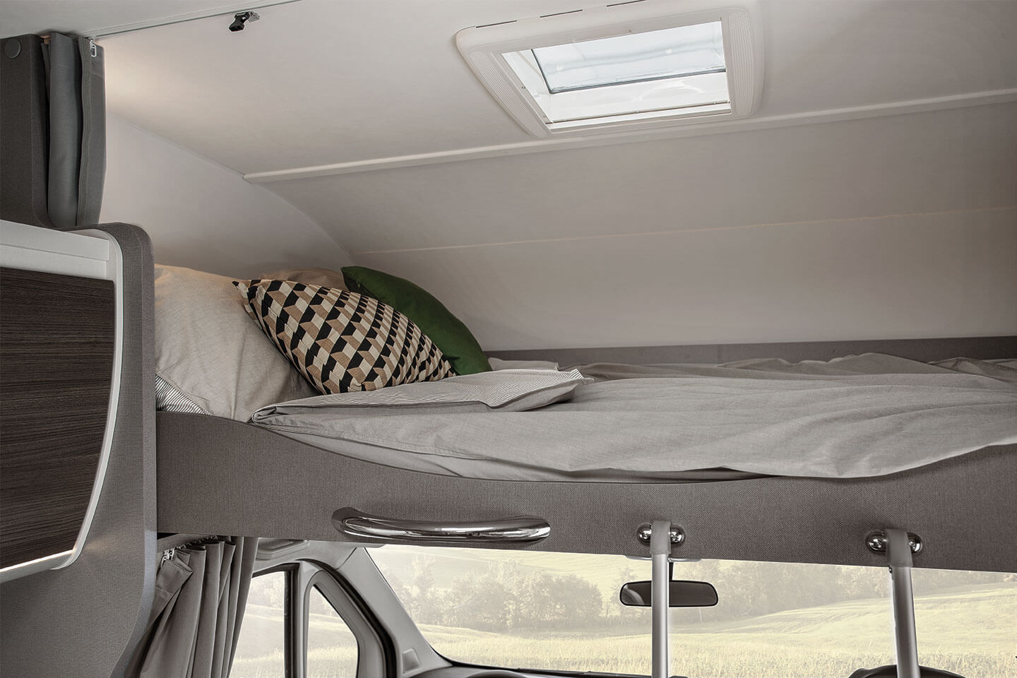 This RV rental features a cozy over-cab bed with bedding, pillows, and a skylight, perfect for travel.. Etrusco Etrusco A7300DB 2021