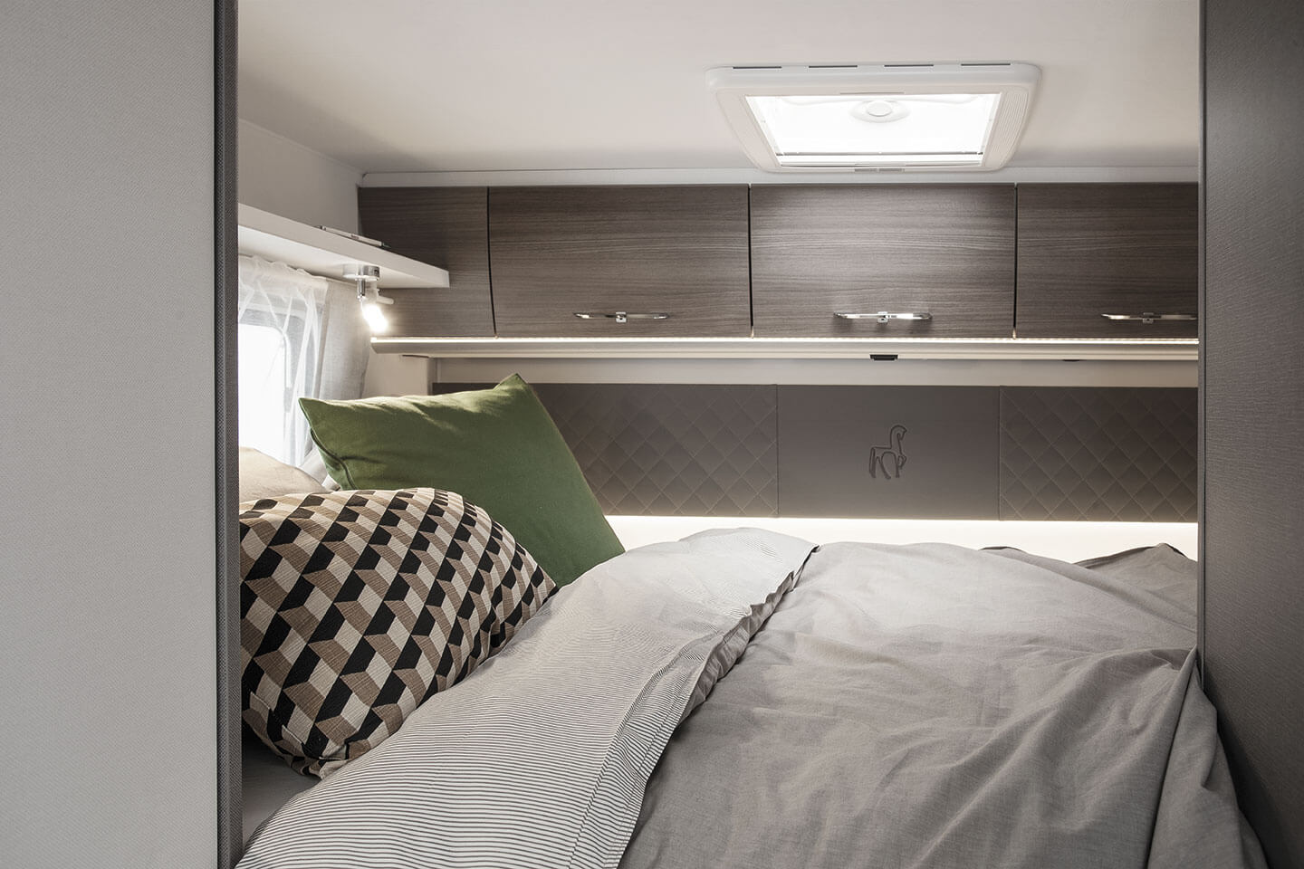 Comfortable RV rental bedroom interior with overhead storage, ambient lighting, and soft bedding for relaxing trips.. Etrusco Etrusco A7300DB 2021