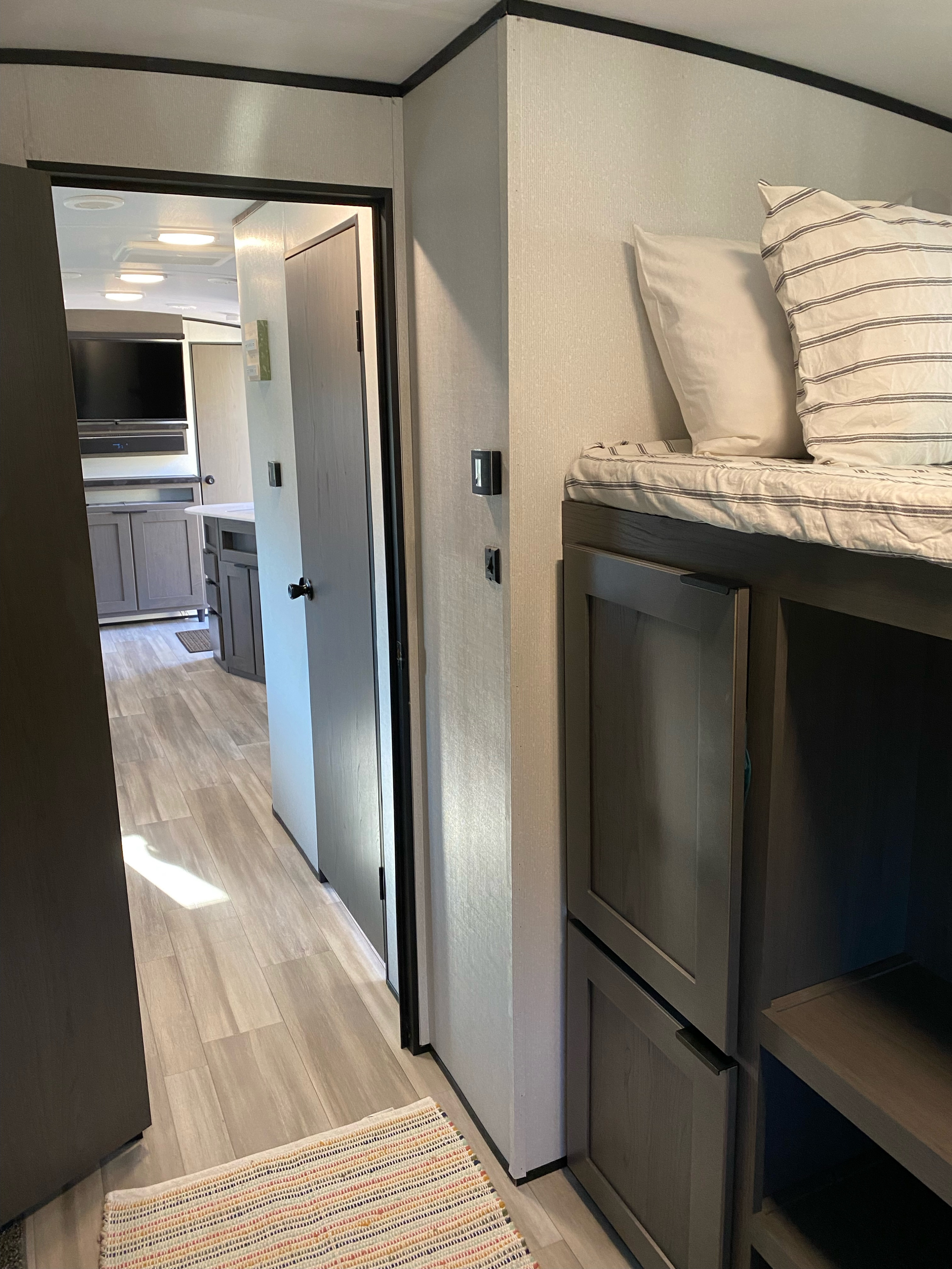 Step into this inviting RV rental. Features bunk beds, light flooring, and a view of the modern kitchen/living area.. Cruiser RV MPG Ultra Lite 2021