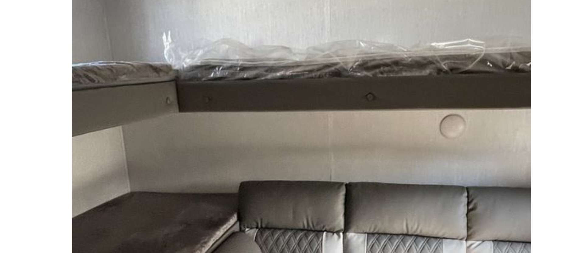 RV rental sleeping area: bunk beds (new mattress wraps) above a plush sofa. Ideal for mobile living.. Forest River Wildwood X-Lite 2022