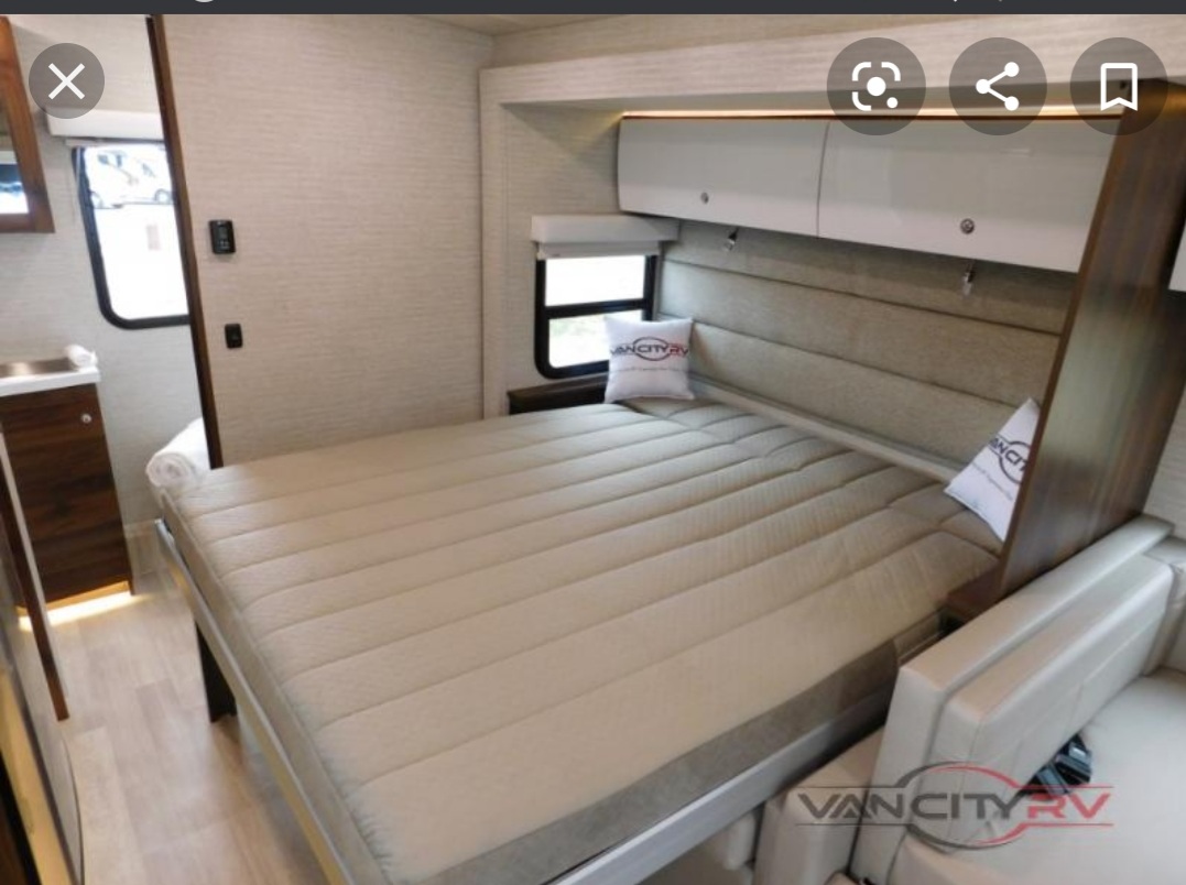 RV rental interior: comfy bed with storage cabinets & small sink. Perfect for your next road trip!. Winnebago Navion 2020