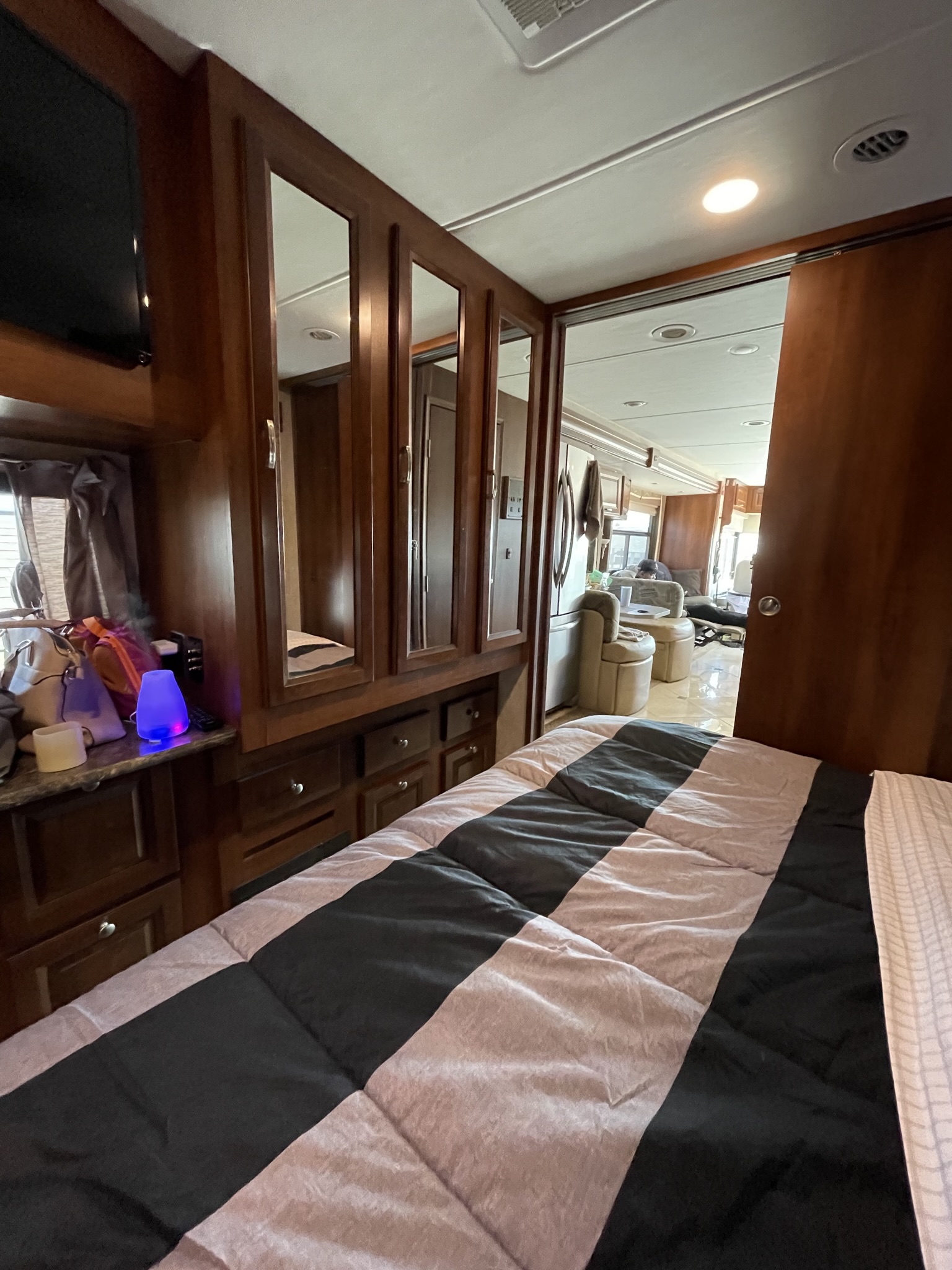 RV rental interior: cozy bedroom with mirrored cabinets and TV, opening to a spacious living area and kitchen.. Georgetown XL 2014