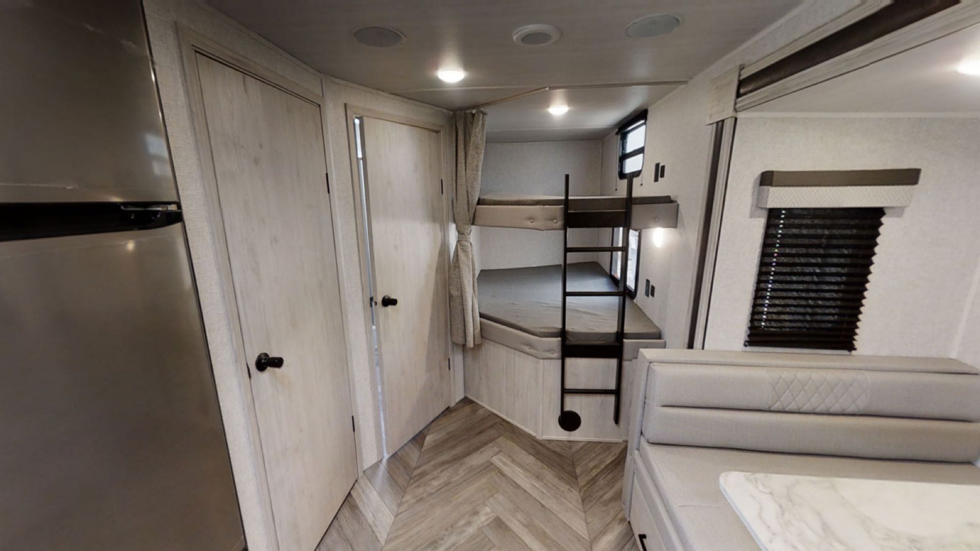 Inside this modern RV rental: comfortable bunk beds, a handy ladder, and a cozy dinette. Ideal for your next family road trip.. East to West Della Terra 2022