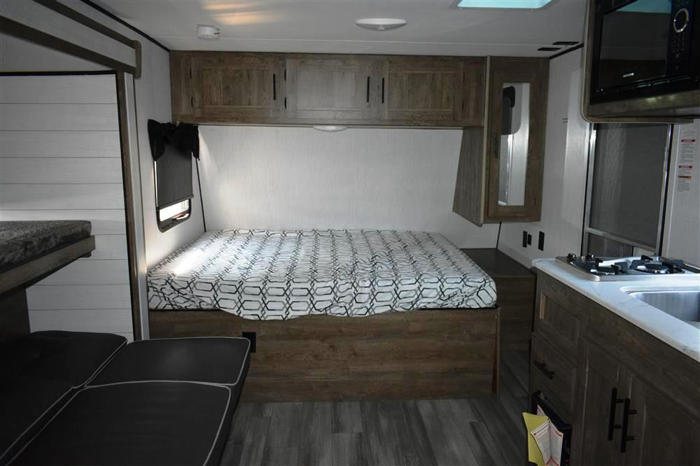 Cozy RV rental interior featuring a main bed, bunk beds, and a kitchen. Ideal for comfortable travel.. Other Pioneer 2022