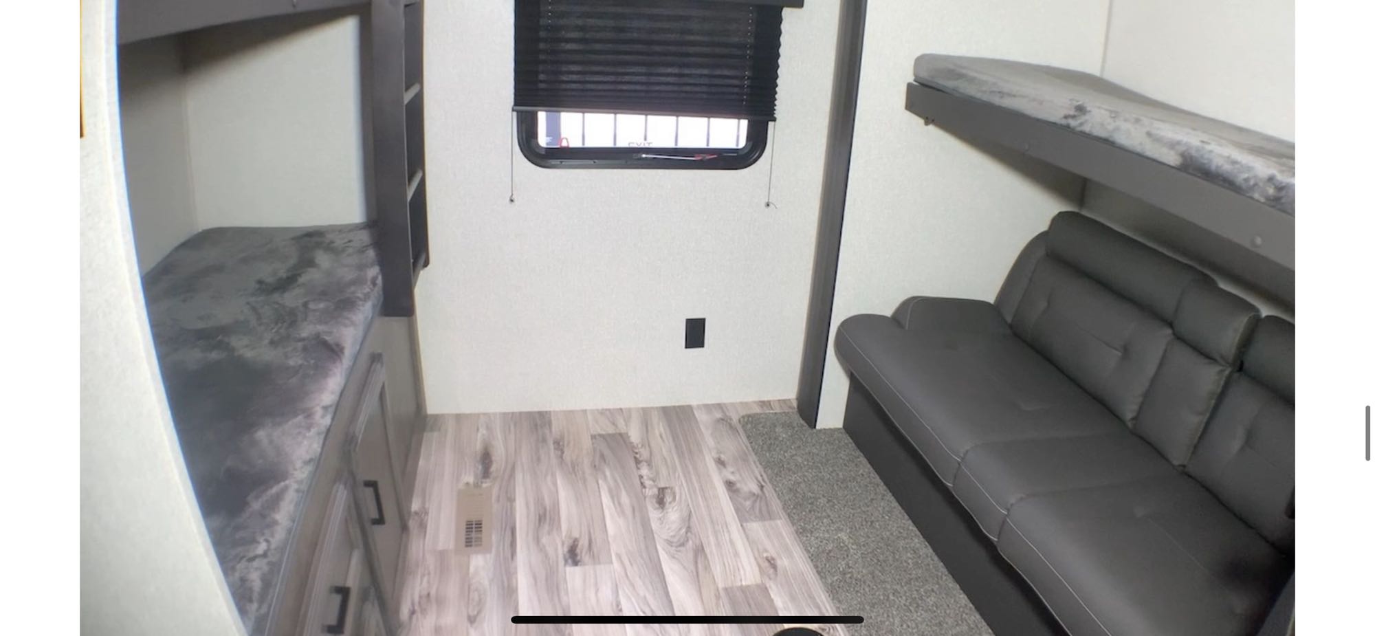 Spacious RV rental interior featuring bunk beds, a comfy sofa, and a window for natural light. Ideal for family trips.. Venture Sporttrek 2022