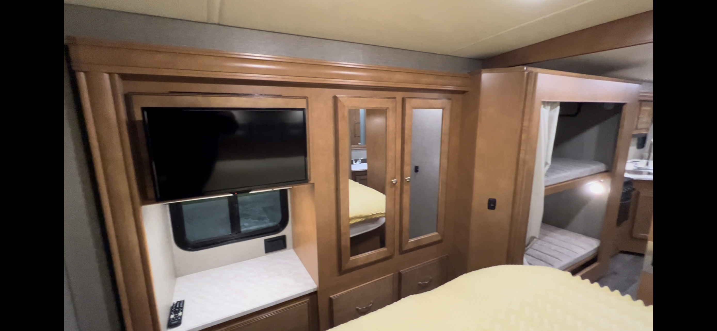 RV rental interior: cozy bedroom with TV, mirrored wardrobe, and bunk beds.. Winnebago Vista 2019