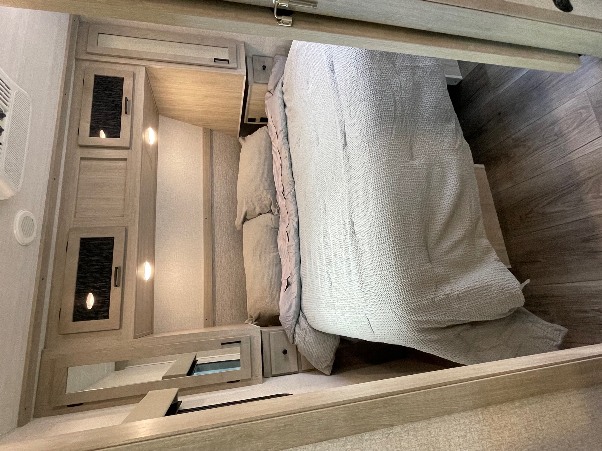 Explore this cozy RV rental bedroom. Features a comfy bed, built-in storage, and soft ambient lighting for your travel comfort.. East to West Alta 2022