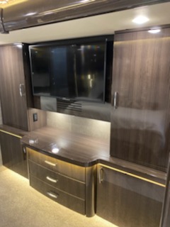 Luxury RV rental bedroom entertainment center with TV, drawers, and storage cabinets. Perfect for your road trip!. American Coach American Heritage 45e 2020