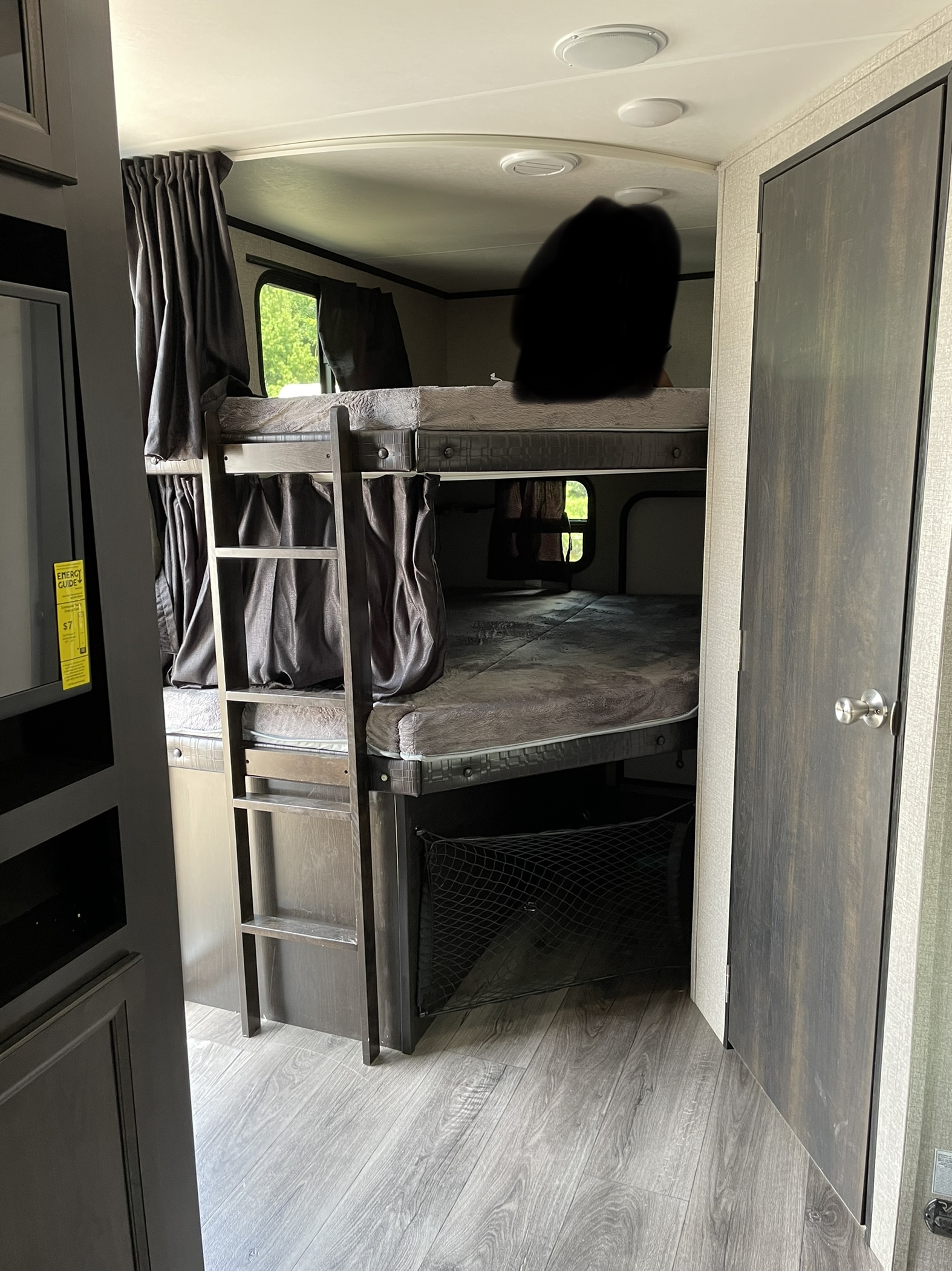 RV rental interior showing stacked bunk beds with privacy curtains, ladder, and a storage net below.. Jayco Jay Feather 2021