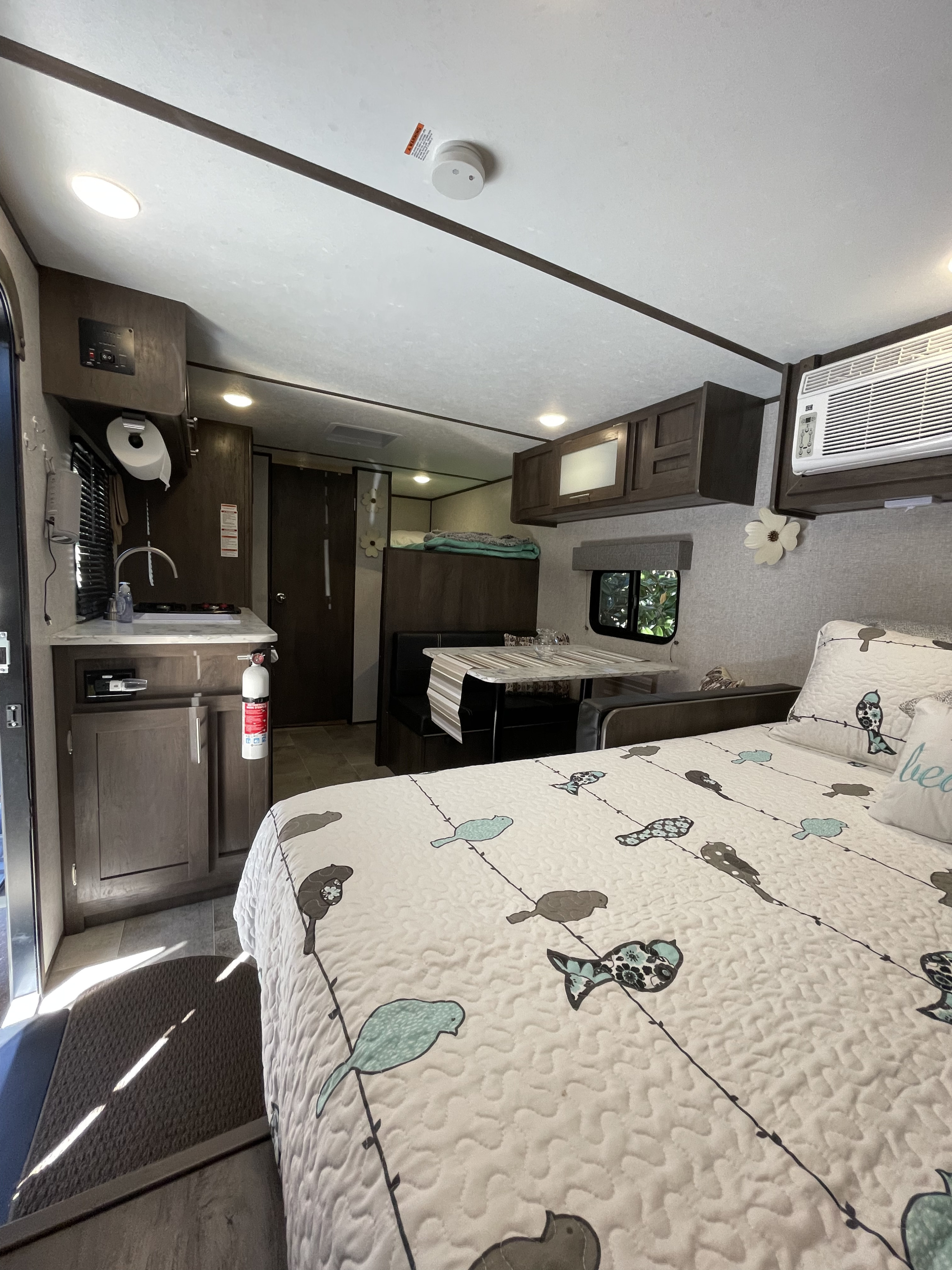 Spacious RV rental interior featuring a bed, kitchen, dinette, and bunk, offering a cozy and functional living space.. Dutchmen Coleman Lantern 2022