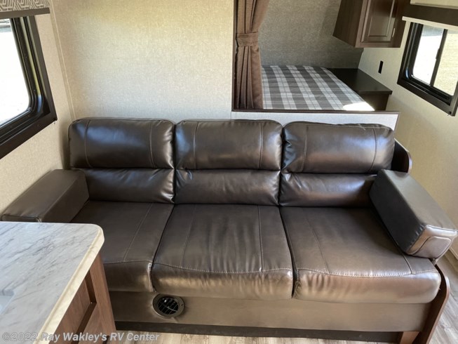 Relax in this RV rental's spacious living area featuring a comfy brown sofa and built-in bunk beds for added sleeping space.. Jayco Jay Flight 2020