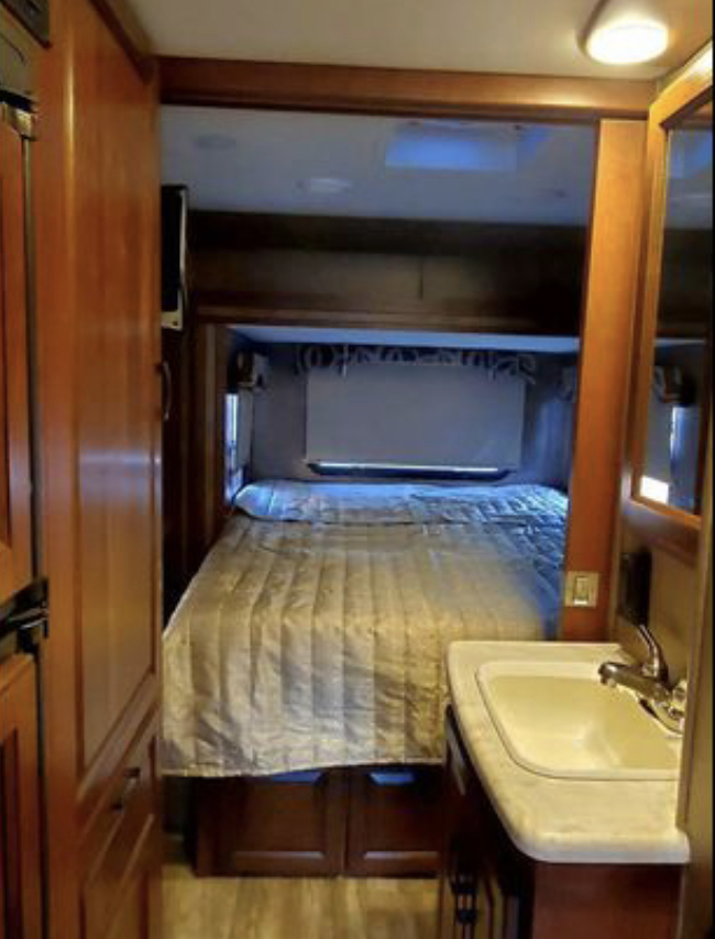RV rental interior showing a compact bedroom with a comfortable bed and a small sink vanity.. Forester MBS 2016