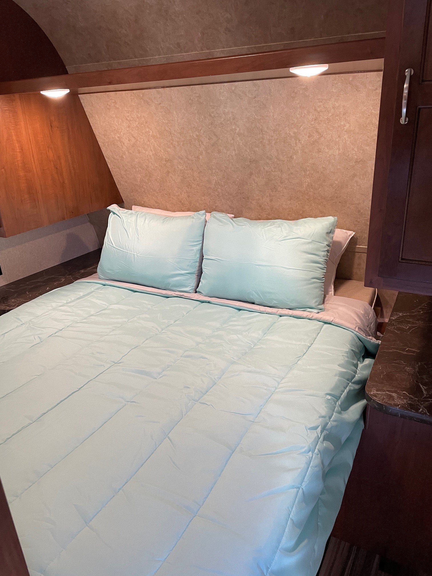 This RV rental offers a cozy, well-lit bedroom featuring a neatly made bed with light blue bedding.. Jayco Jay Flight SLX BHSW 2017