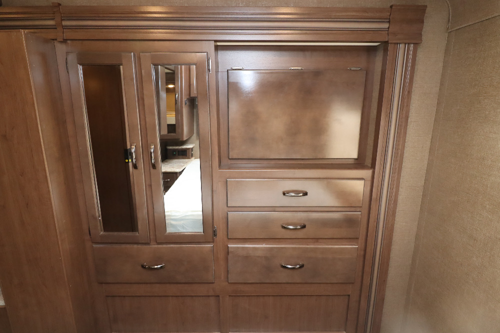 RV rental bedroom storage. Wooden wardrobe with mirrored doors & multiple drawers for clothes & essentials.. Thor Freedom Elite 2019