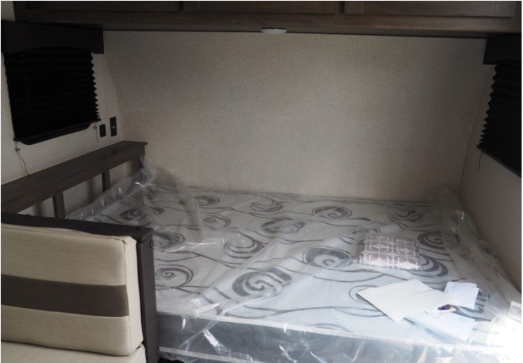RV rental bedroom: New mattress in plastic, compact layout with bedside shelf and window blinds. Clean and ready.. Clipper Clipper Trailer 2021