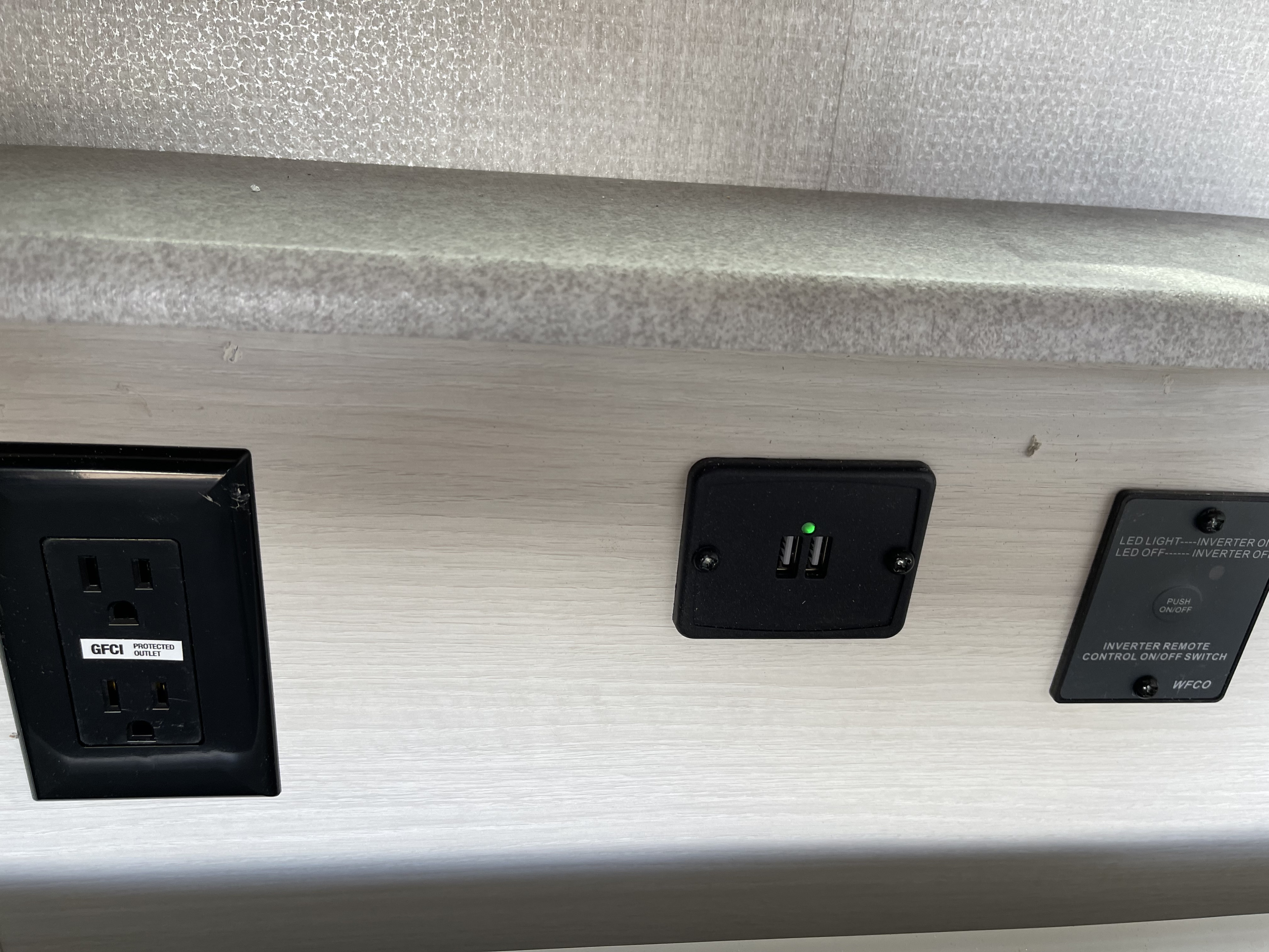 RV rental electrical hub: GFCI outlet, USB charging, and inverter remote control for guest convenience.. Forest River RPod193 2022