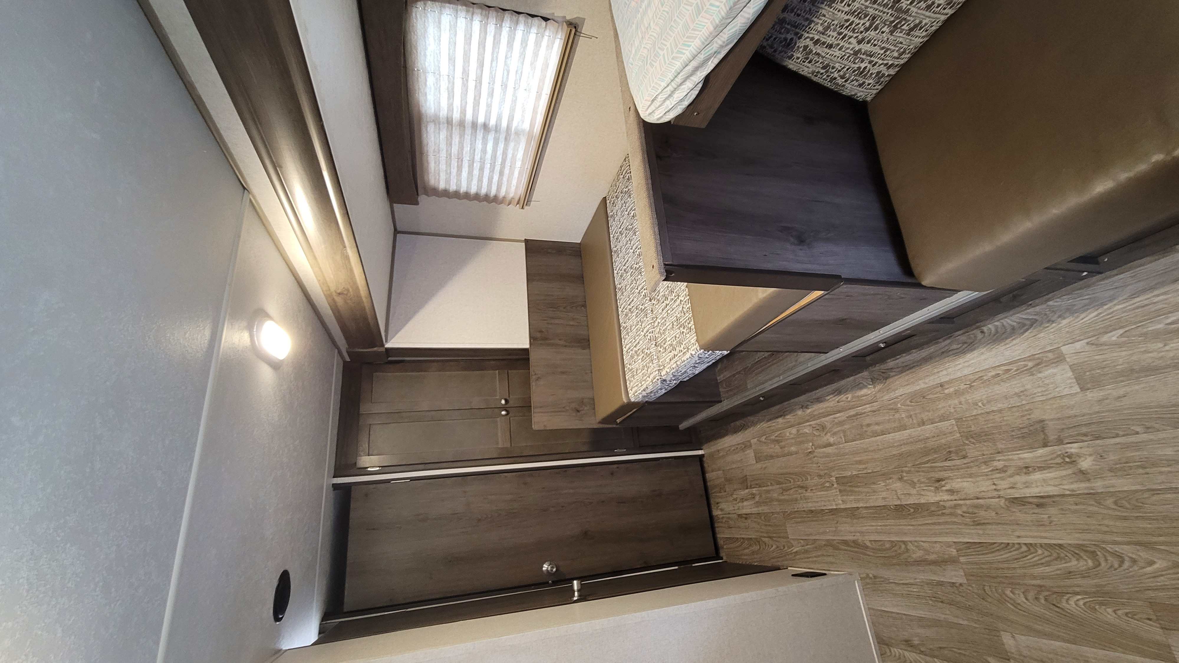 Inside a spacious RV rental, showing a comfortable bed/dinette area, modern cabinetry, and wood-look flooring.. Coachmen Viking 2019