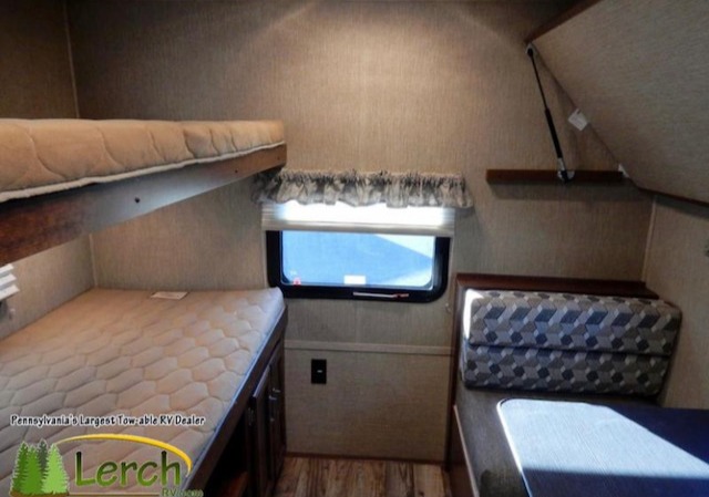 RV rental interior featuring bunk beds, a large window, and a dinette seating area. Ideal for family camping.. Keystone RV Outback Ultra-Lite 2017