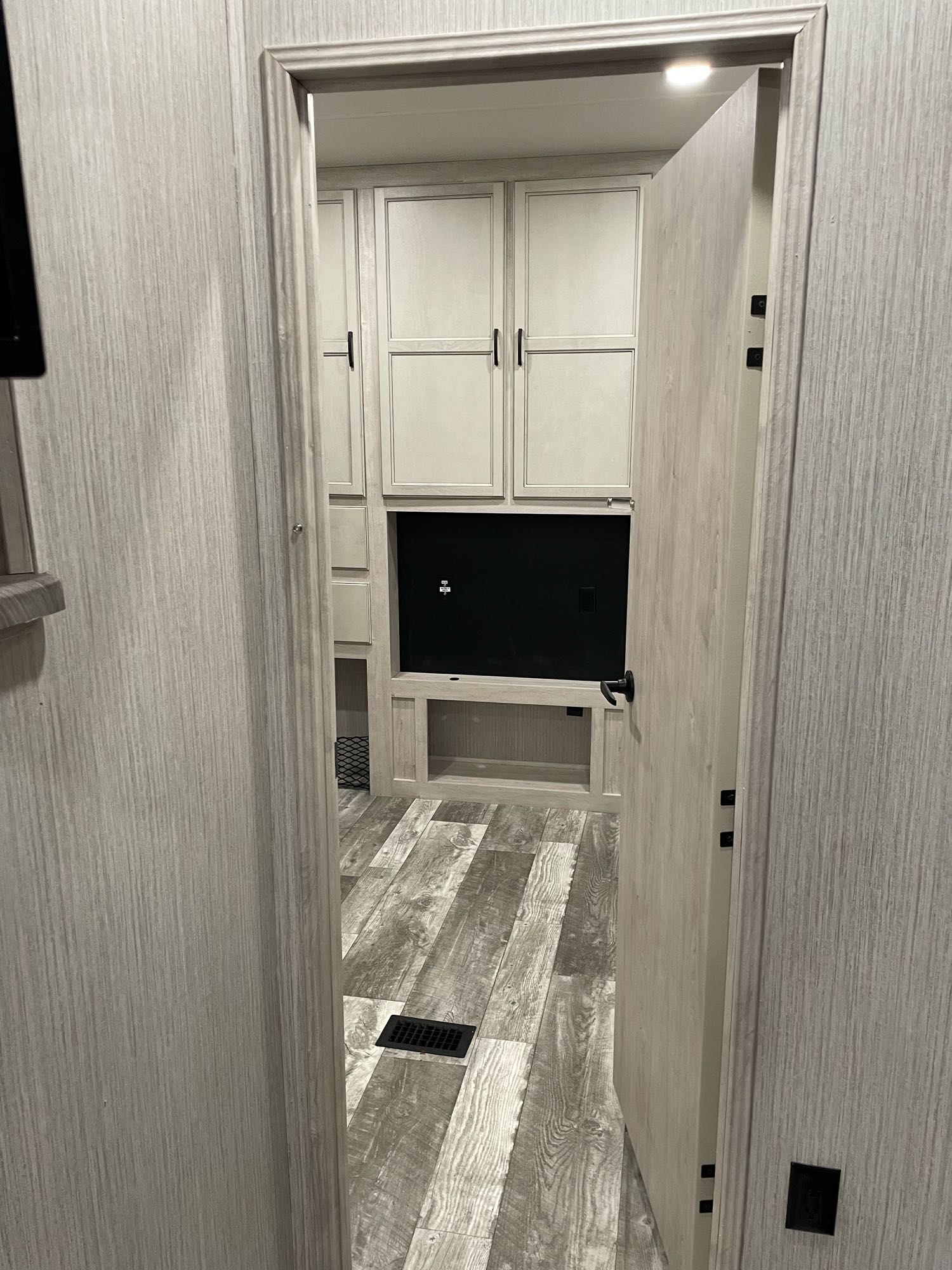 Modern RV rental interior featuring light wood cabinets, built-in TV, and wood-look flooring seen through a doorway.. Forest River Other 2022