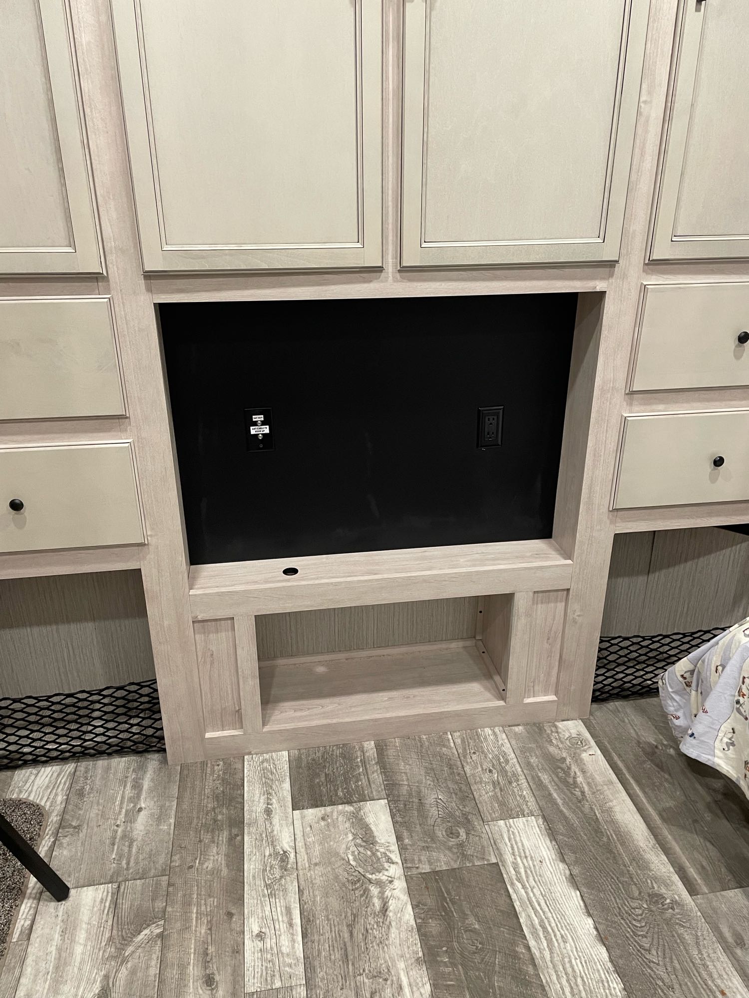RV rental interior: A light-toned wood wall unit features a central TV cutout with power, surrounding cabinets, and storage.. Forest River Other 2022