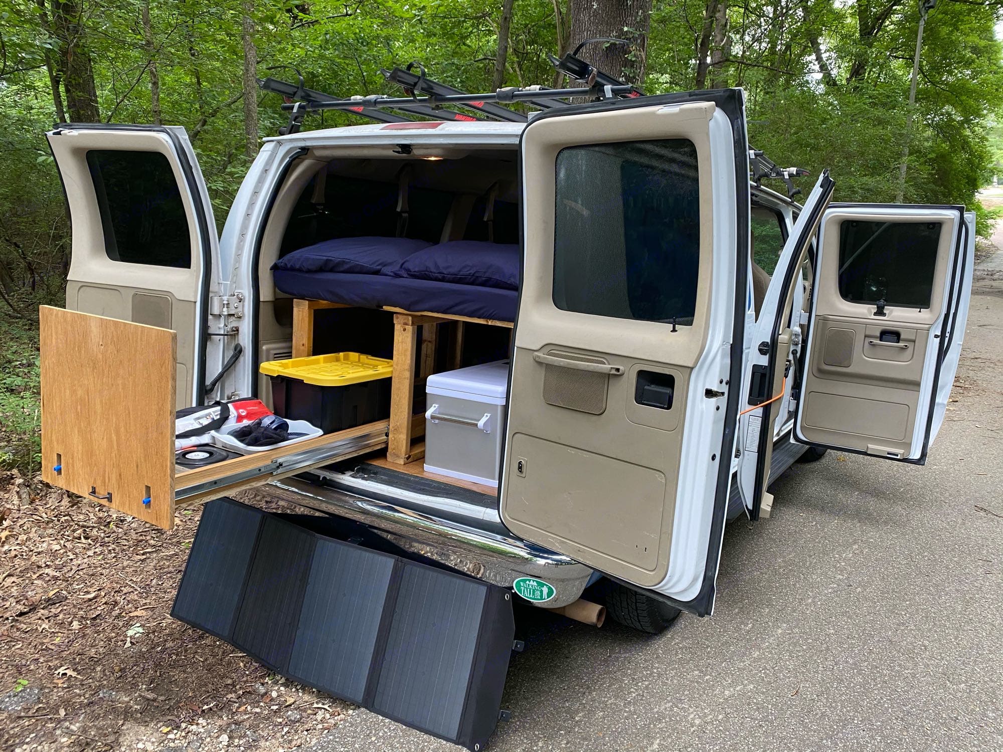 Check out this spacious RV rental campervan conversion, featuring a cozy bed, pull-out storage, and a portable solar panel.. Ford Econoline 2012