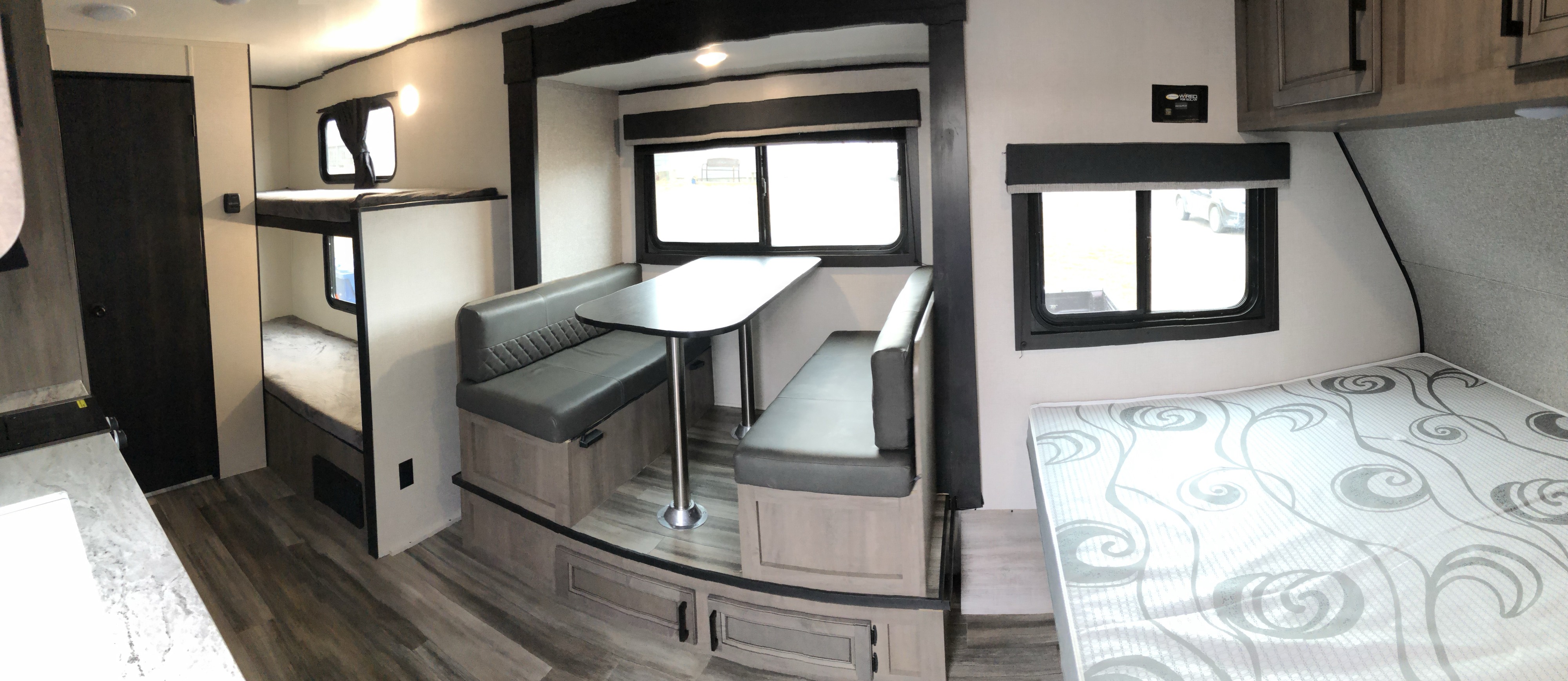 RV rental interior: bunk beds on left, dinette with table in center, and a main bed on right, offering comfort.. Starcraft Autumn Ridge BHS180 2022