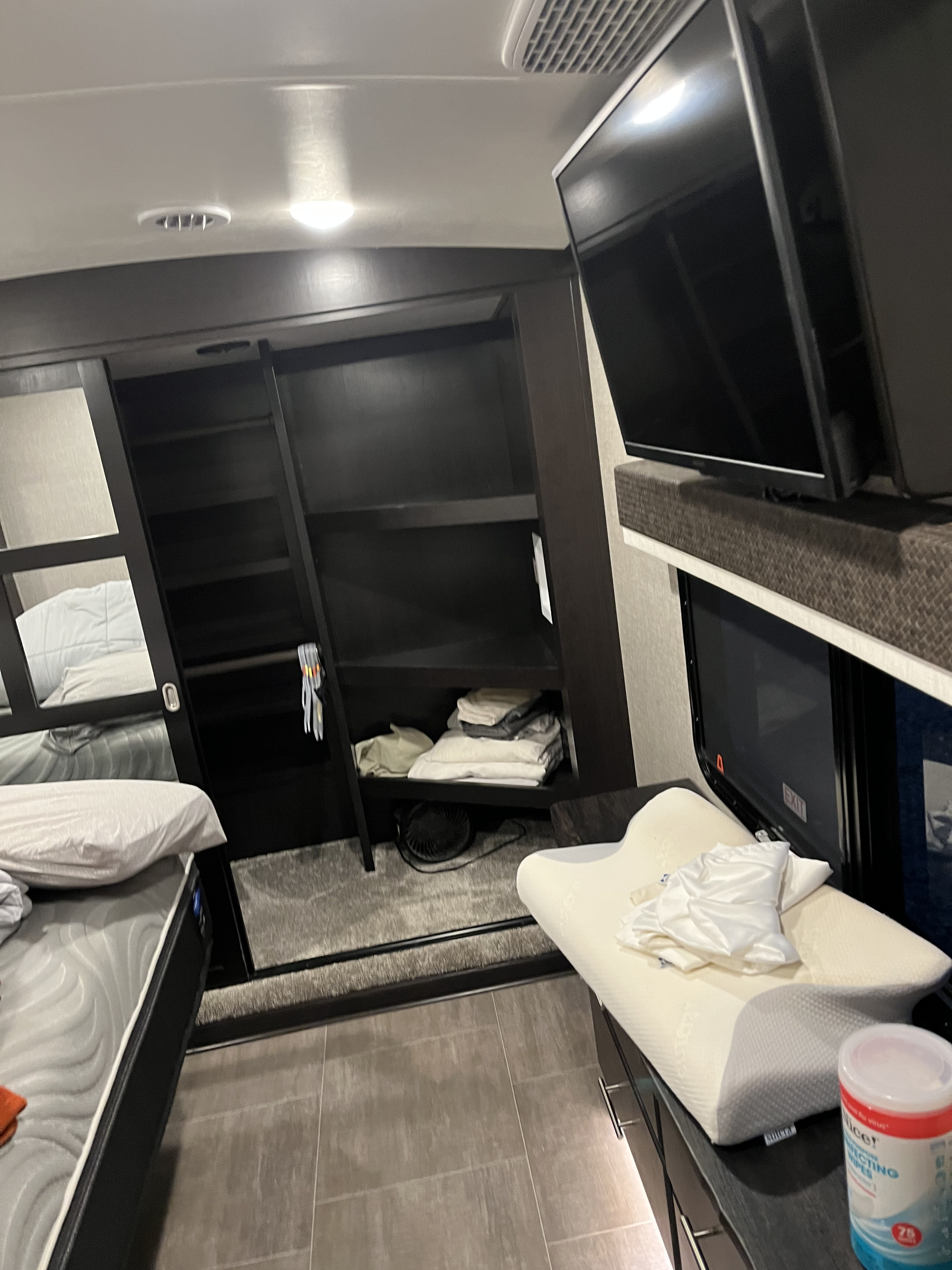 Inside an **RV rental**: compact bedroom with bunk beds, TV, storage, and cleaning wipes for a comfy trip.. Jayco North Point 2022