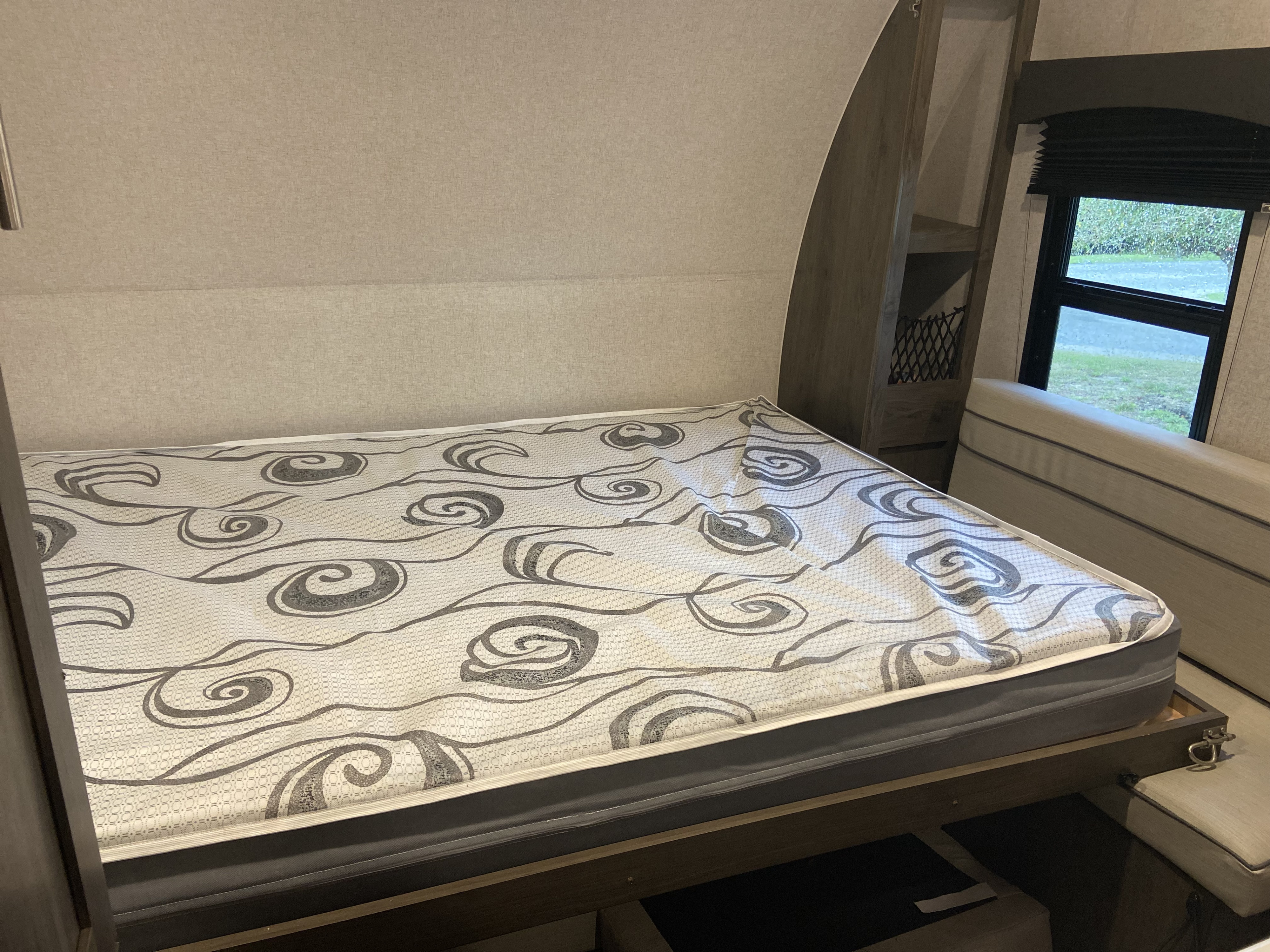 RV rental: Bed with grey patterned mattress, window, storage shelves, and under-bed storage for travel.. Clipper Other 2021