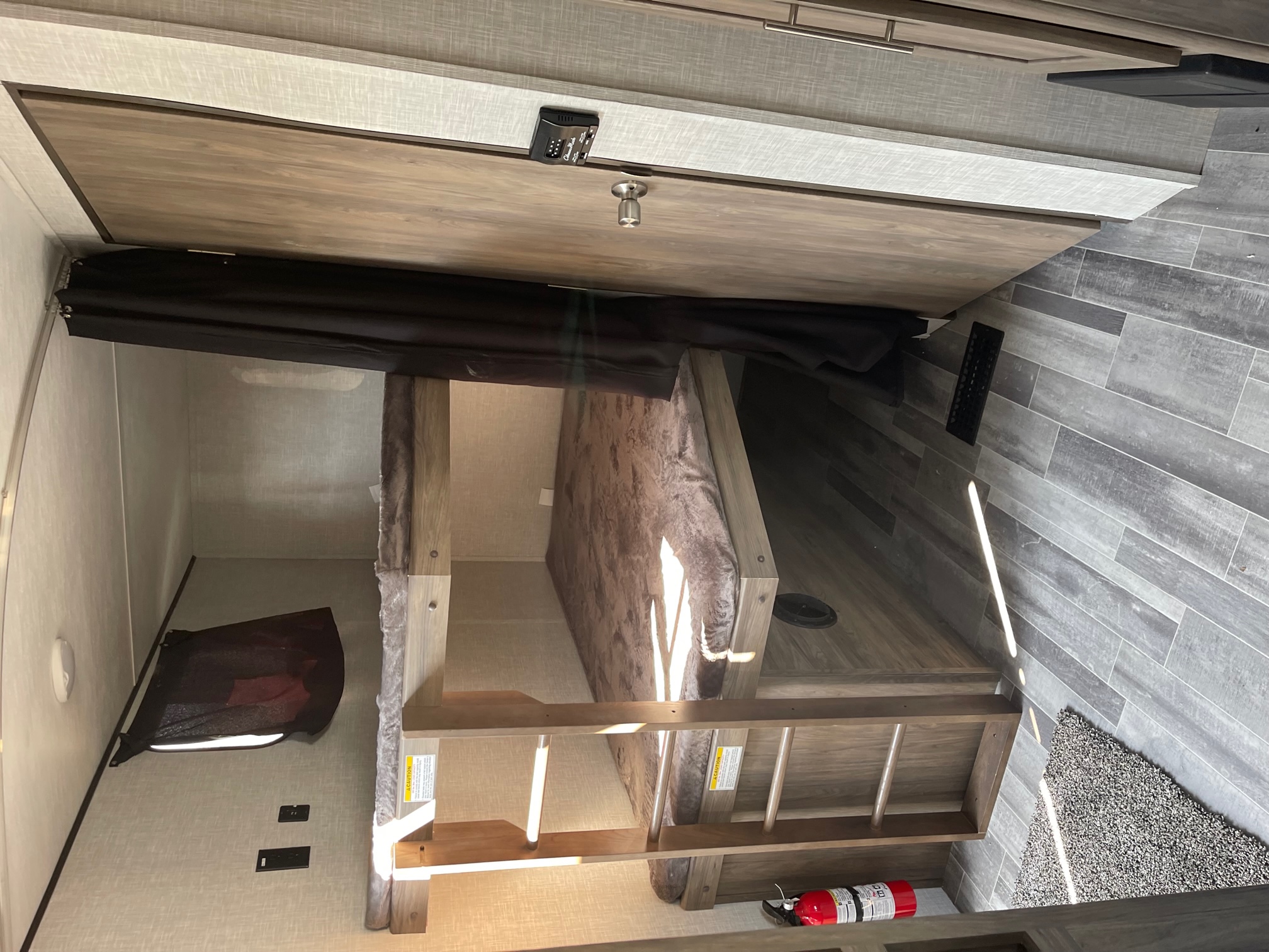 Inside an RV rental: a cozy bunk bed area with ladder, curtain, and fire extinguisher, ready for your next adventure.. Zinger Crossroads ZR280BH22 2022