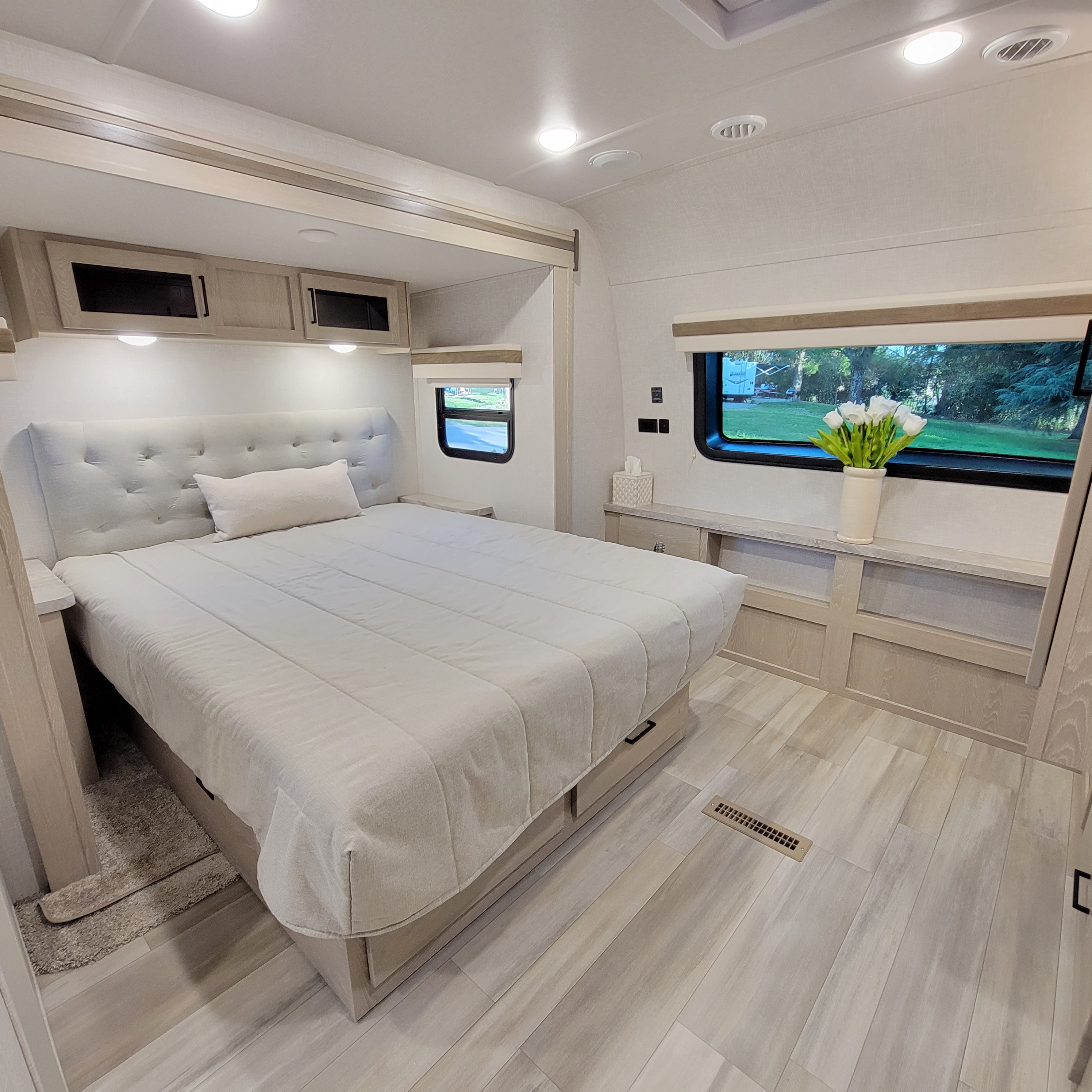 Spacious and modern RV rental bedroom with light wood accents, comfortable bed, and scenic views. Perfect for your next adventure!. Forest River Rockwood 2022