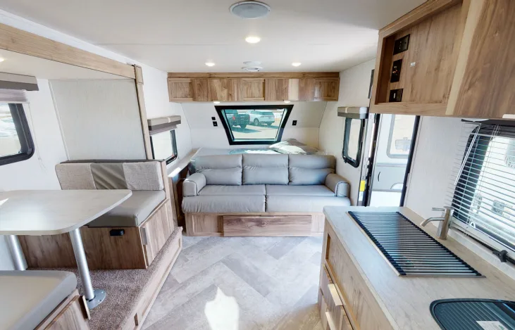 Clean, bright rv rental interior with a dinette, versatile sofa bed, rear sleeping area, and essential kitchen amenities.. Forest River Palomino Palomini 2021