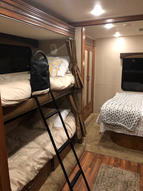 Inside this RV rental: comfortable bunk beds with a ladder on the left, and a plush master bed on the right.. Jayco Greyhawk 2016