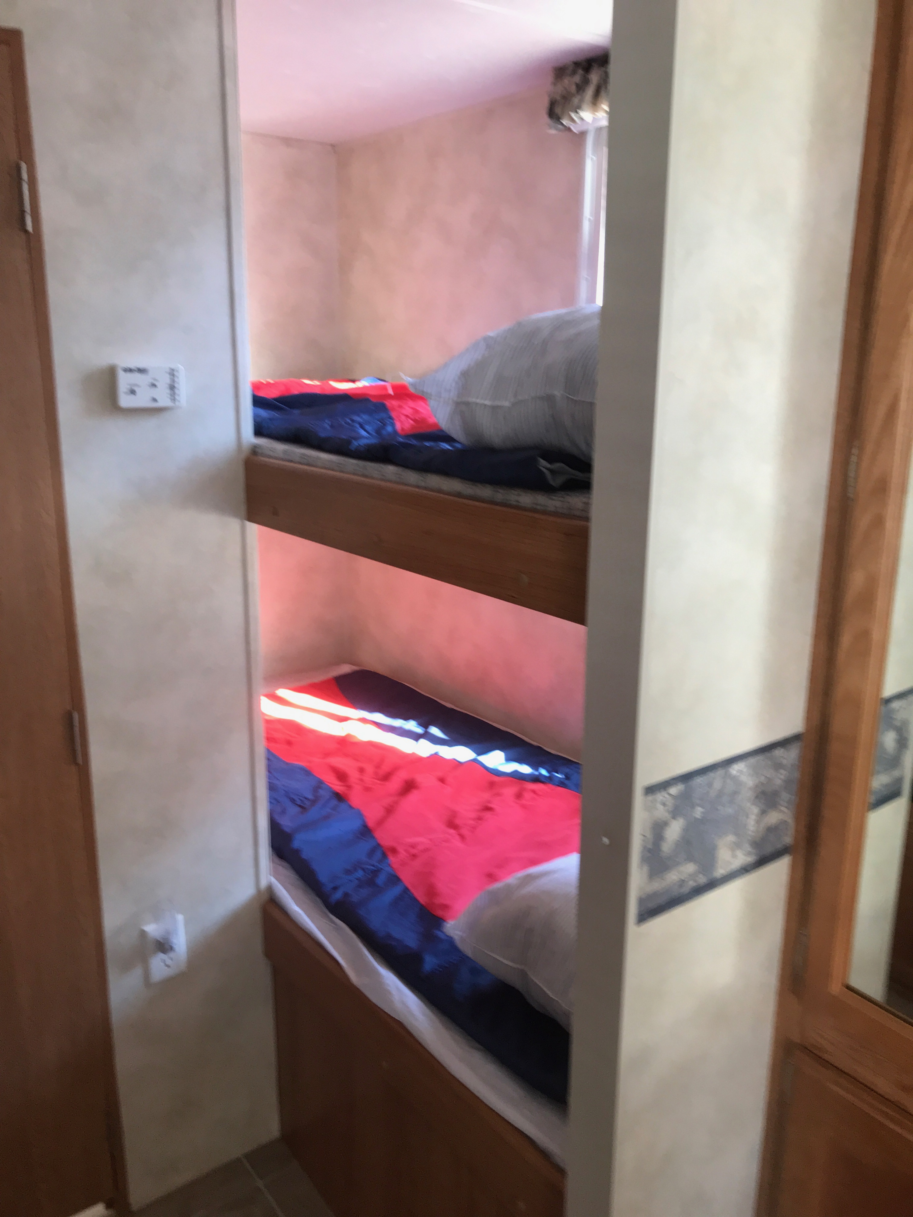 This RV rental offers comfortable bunk beds, complete with vibrant red and blue bedding, ideal for families.. Palomino Puma 2006