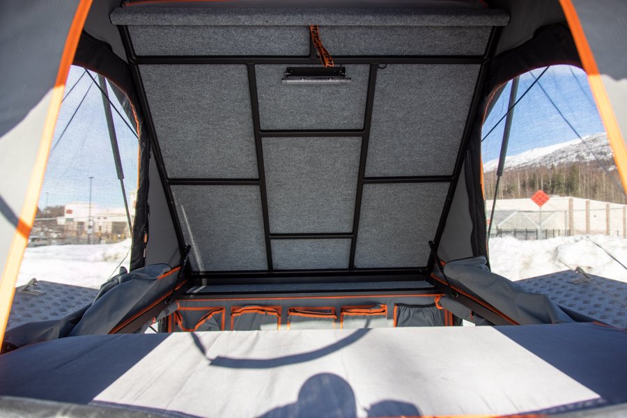 Inside a pop-up rooftop tent, perfect for an RV rental. Features a felt-lined ceiling, integrated light, and organized storage.. Toyota Tacoma 2022
