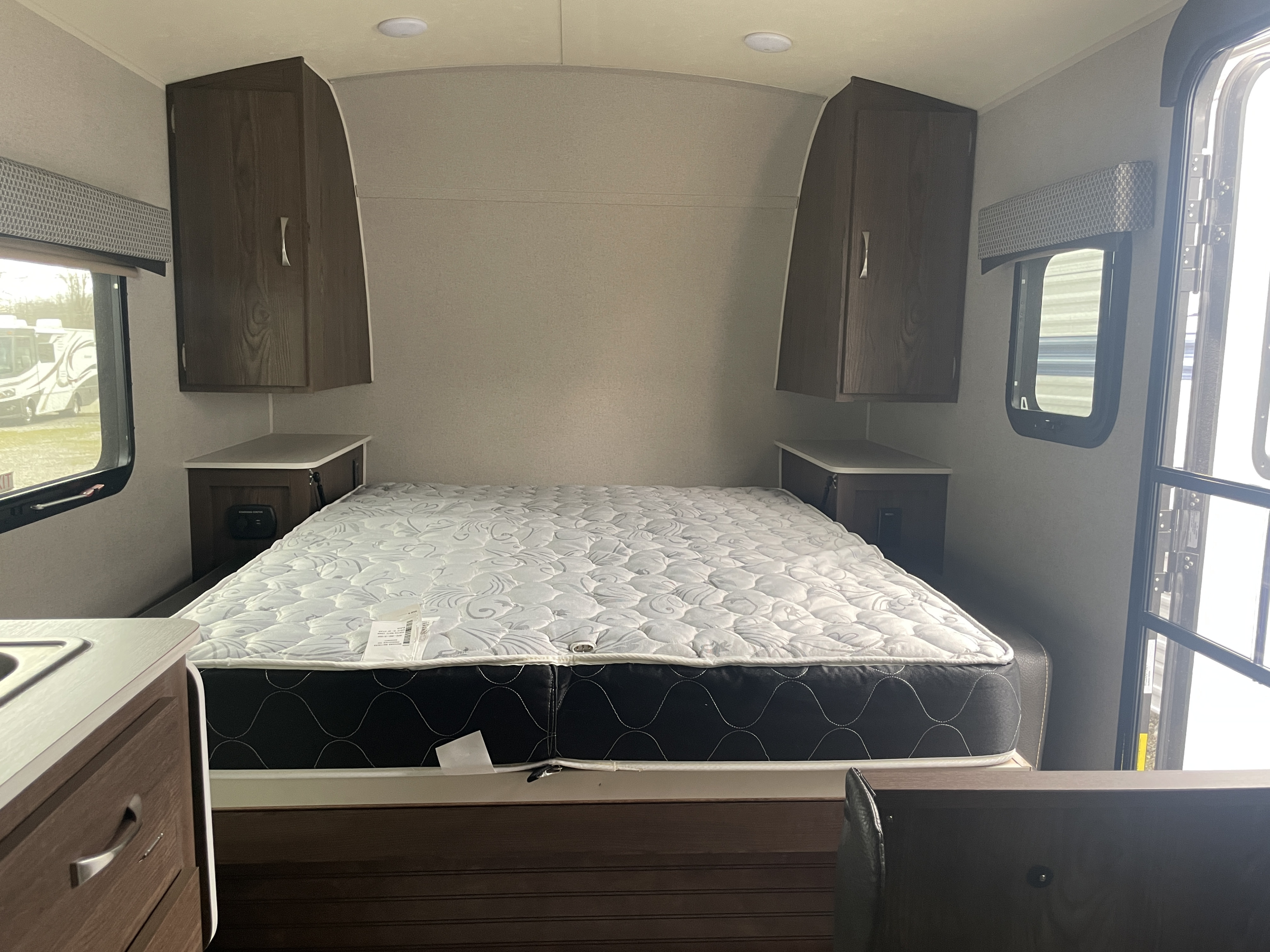 RV rental interior: compact bedroom with comfortable mattress, bedside storage, and overhead cabinets.. Forest River GeoPro 2018