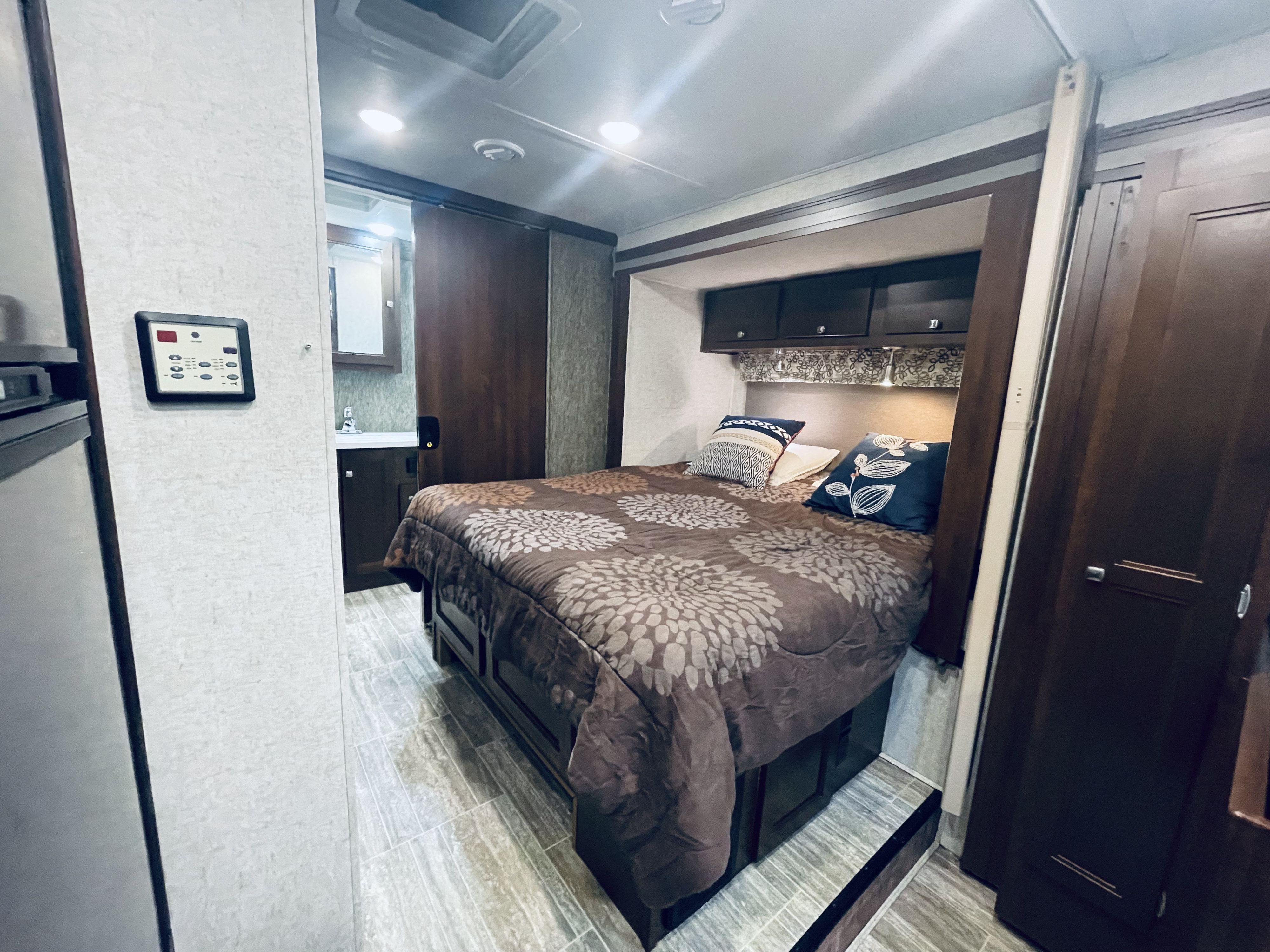 Inside a spacious RV rental bedroom featuring a full bed, built-in storage, and a private sink area.. Forest River Forester 2018