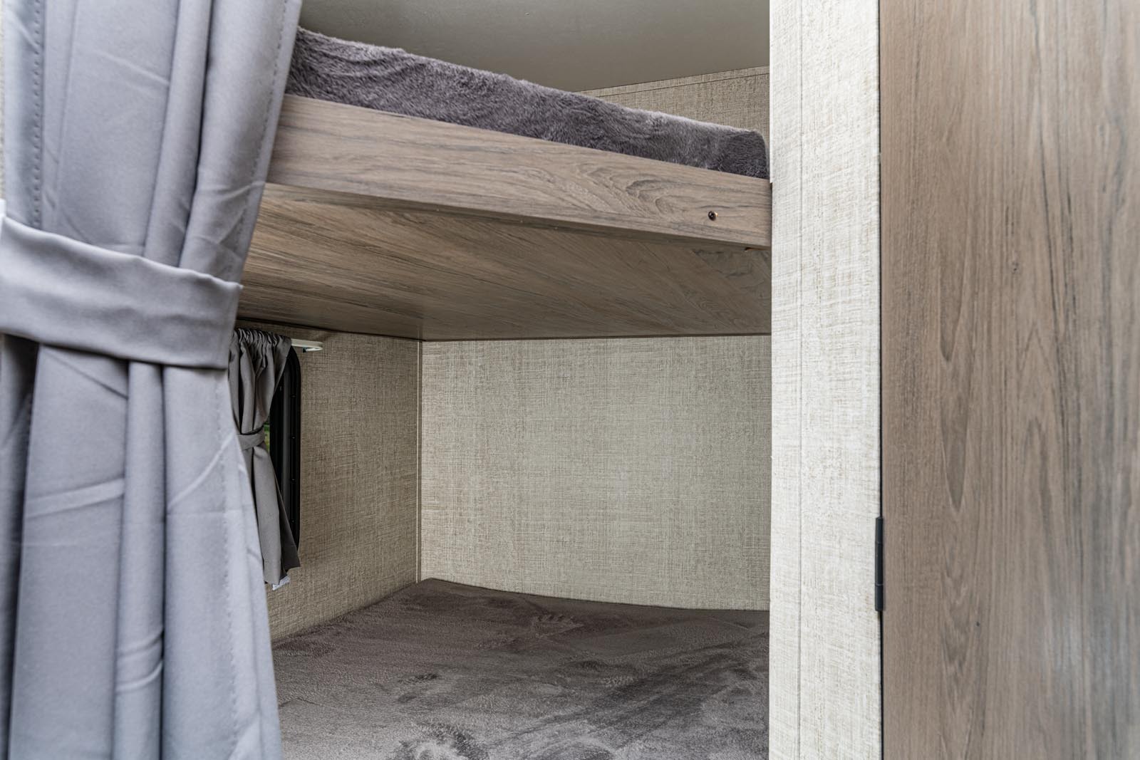 RV rental with comfy, space-saving bunk beds. Features soft grey bedding and wood-look interior for family travel.. Gulfstream 26BHG 2022