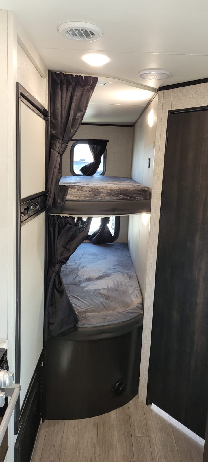 Inside an RV rental: two cozy bunk beds with privacy curtains and individual windows for a comfortable stay.. Jayco Jay Flight 2022