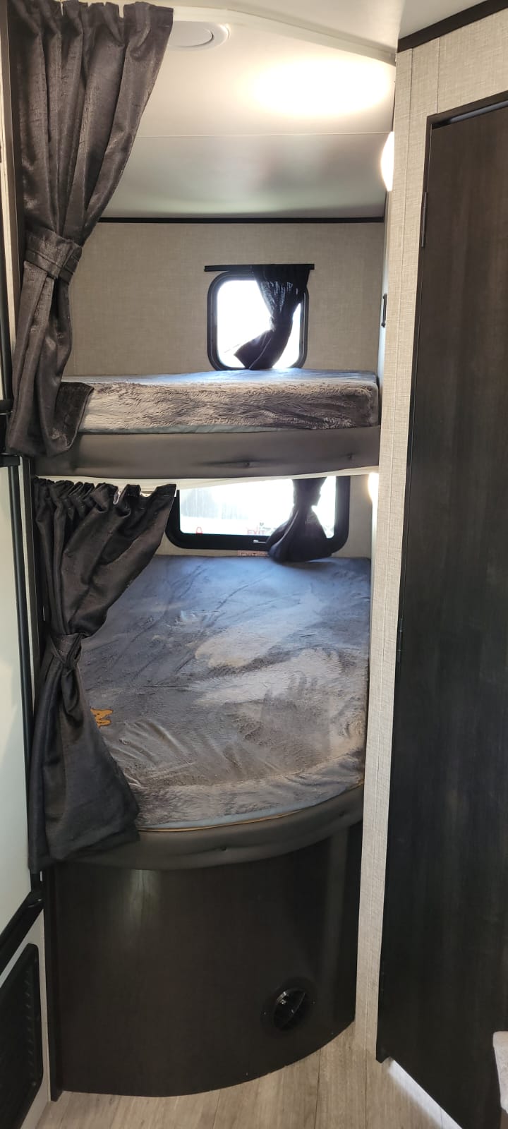 RV rental: Cozy bunk beds with windows and privacy curtains inside a clean, modern travel trailer.. Jayco Jay Flight 2022