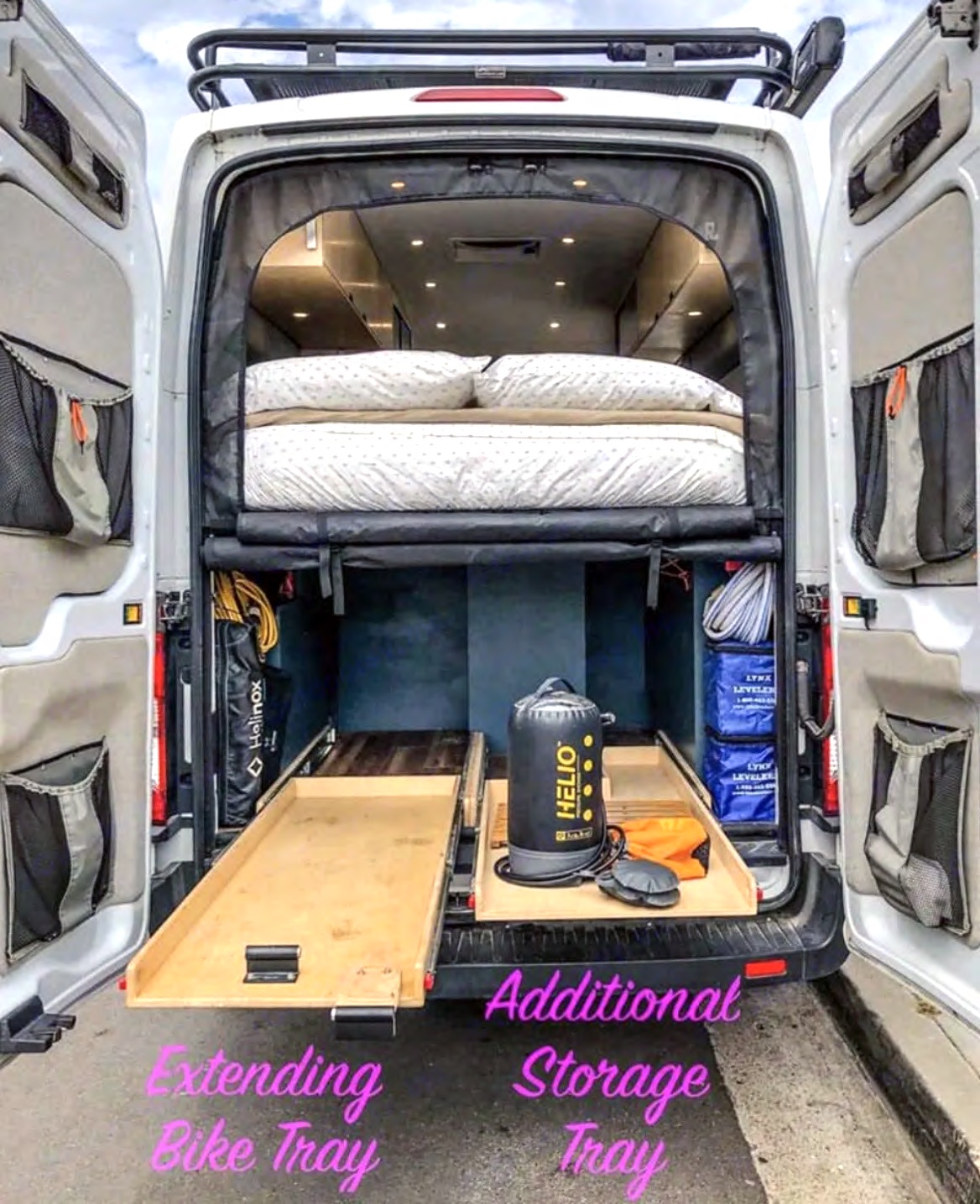 RV rental interior view: elevated bed, extending bike tray, & additional storage show a well-equipped camper van.. Ford Transit 2015