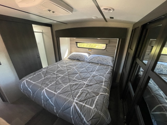 RV rental bedroom: Features a comfy queen bed, AC, sliding bath door, and mirrored closet.. Crossroads RV Cruiser Aire 2021