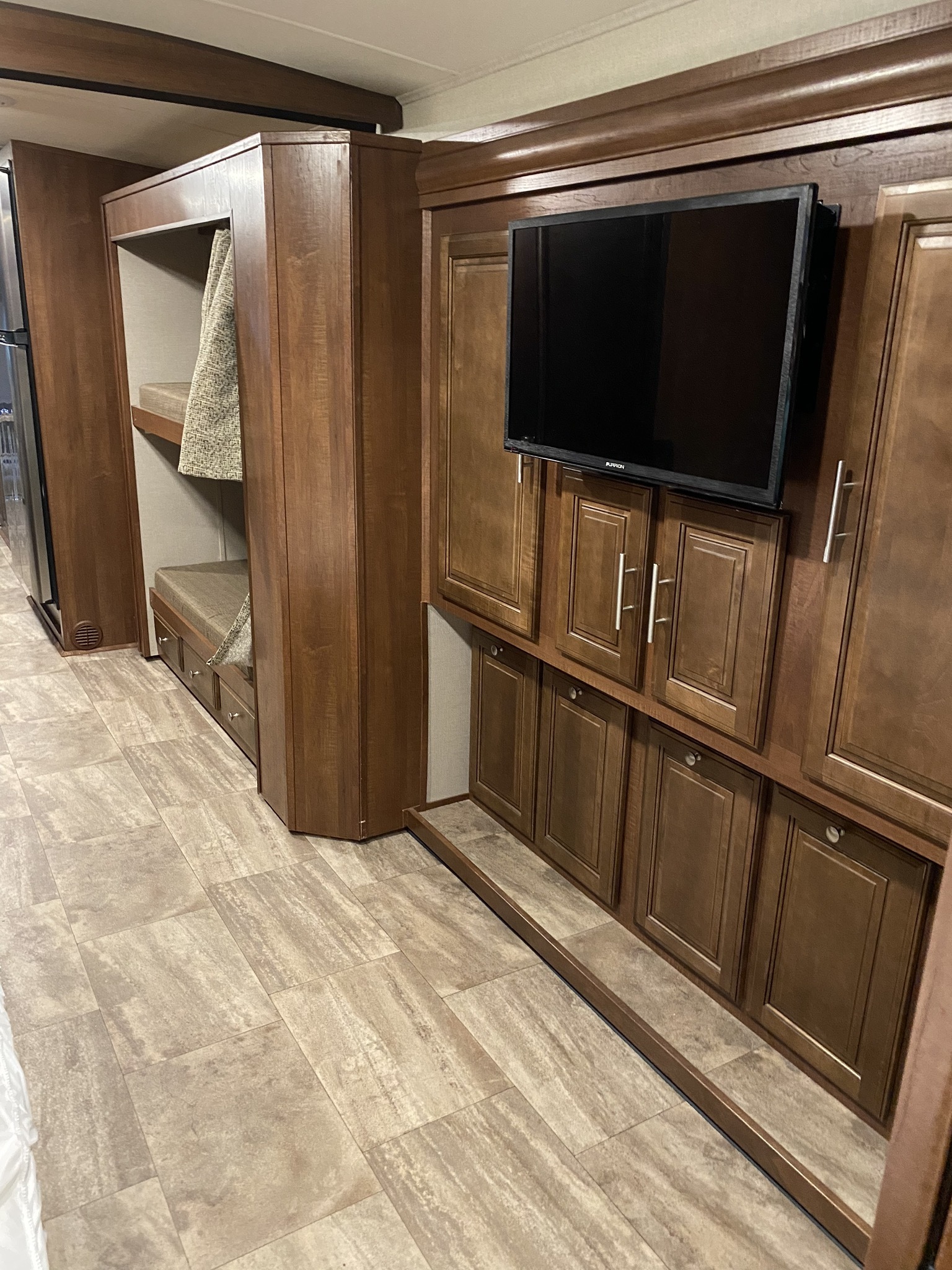 This RV rental interior features bunk beds with storage, a mounted TV, and extensive cabinetry, offering comfort for travel.. Forest River 36B5 2017