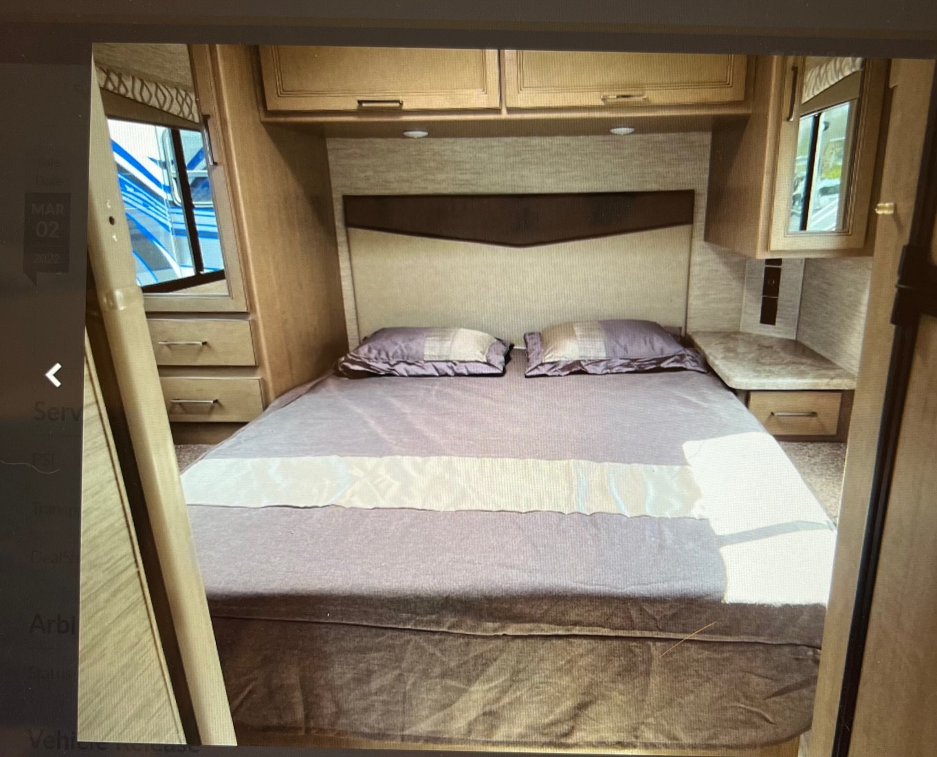 Comfortable RV rental bedroom with spacious bed, overhead cabinets, and natural light, perfect for your next adventure.. Thor Quantum 2021