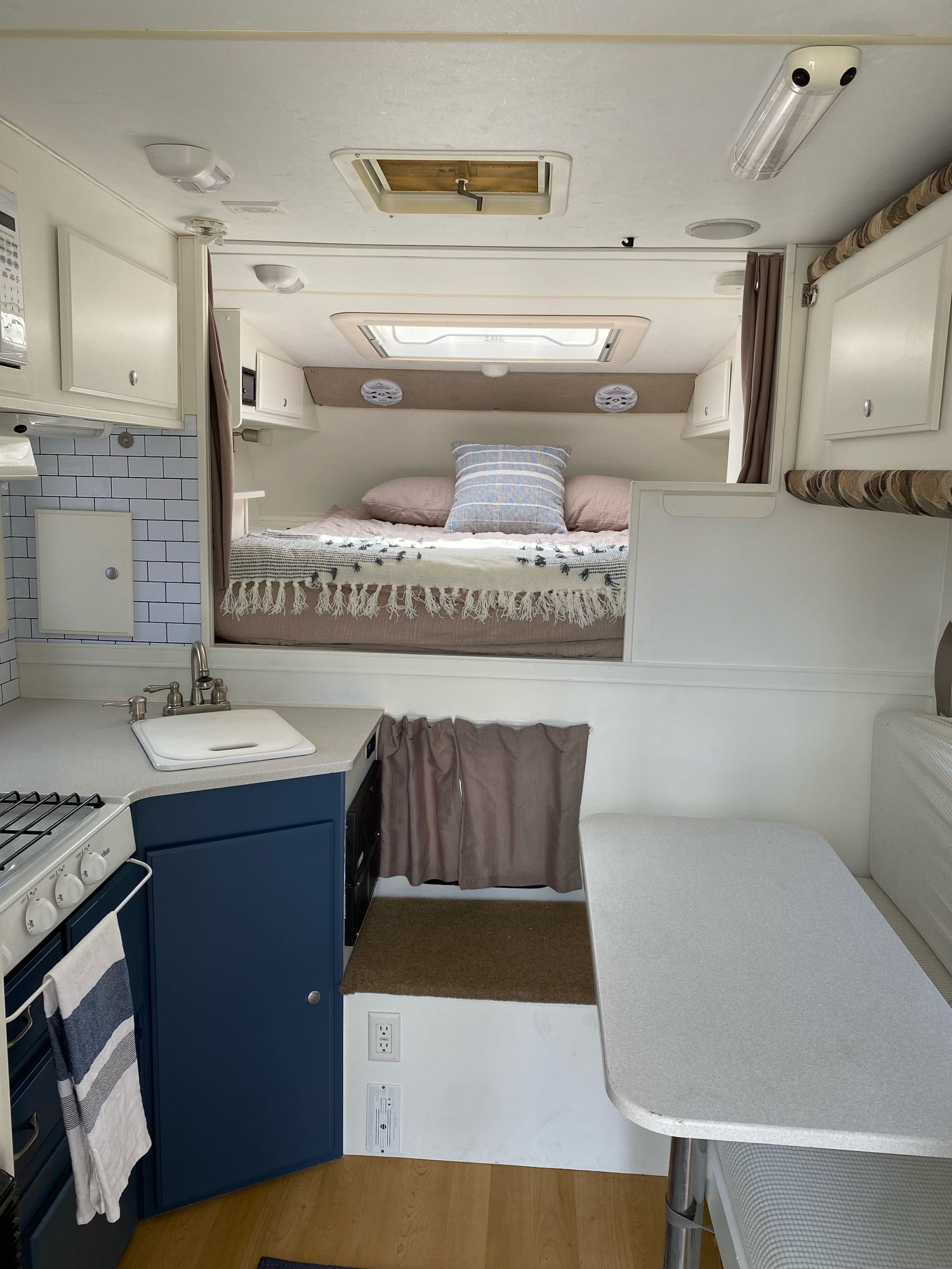 Cozy RV rental interior with kitchen, bed, and dinette. Ideal for travel adventures.. Ford F350 2022