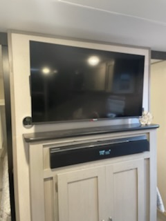 Modern RV rental interior with a large mounted TV and soundbar over storage cabinets, offering entertainment on the go.. Forest River Tracer 2022