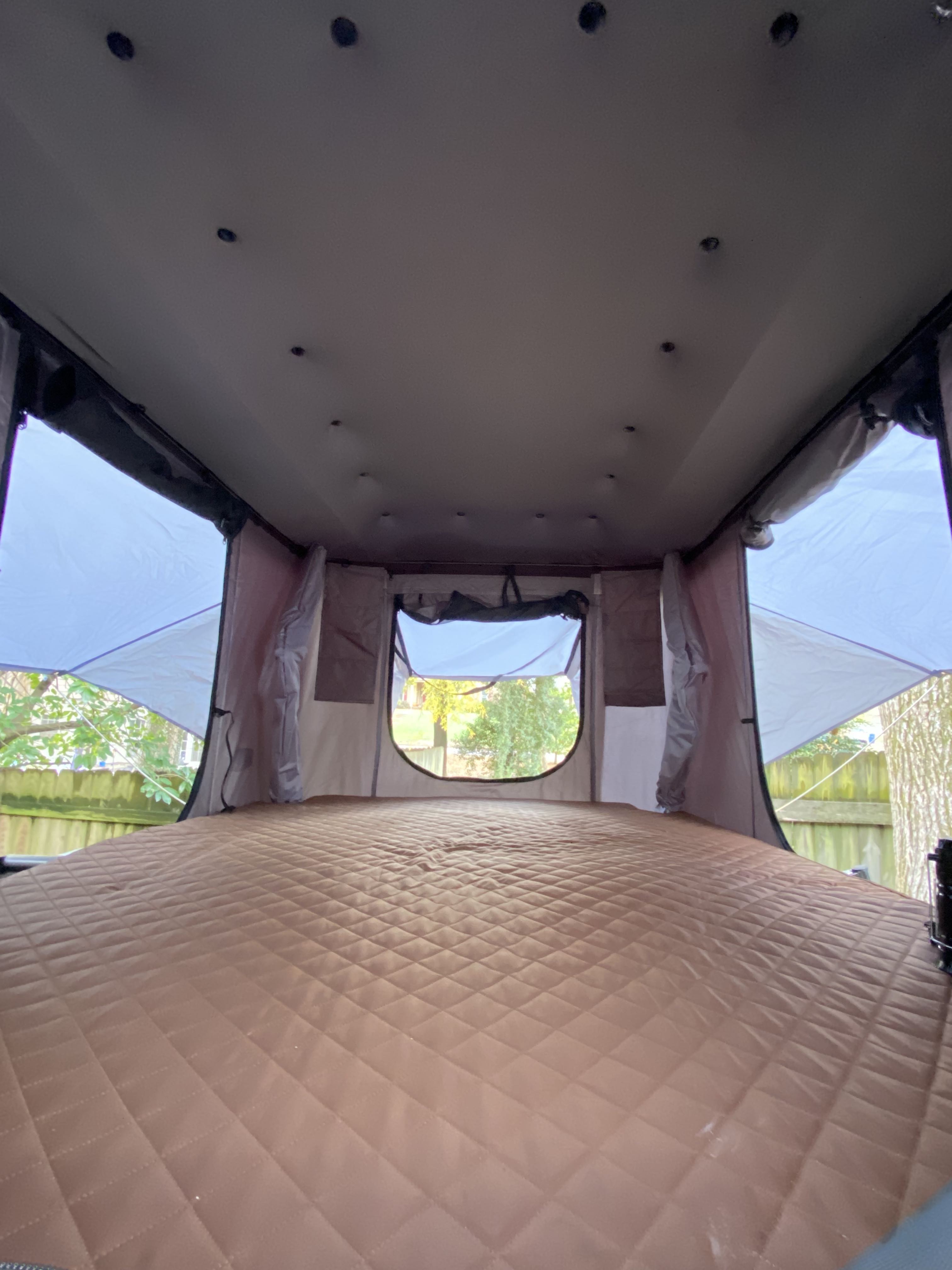 Spacious rooftop tent interior with a plush, quilted sleeping pad – ideal for your next RV rental getaway.. Runaway Campers Rangerunner 2016