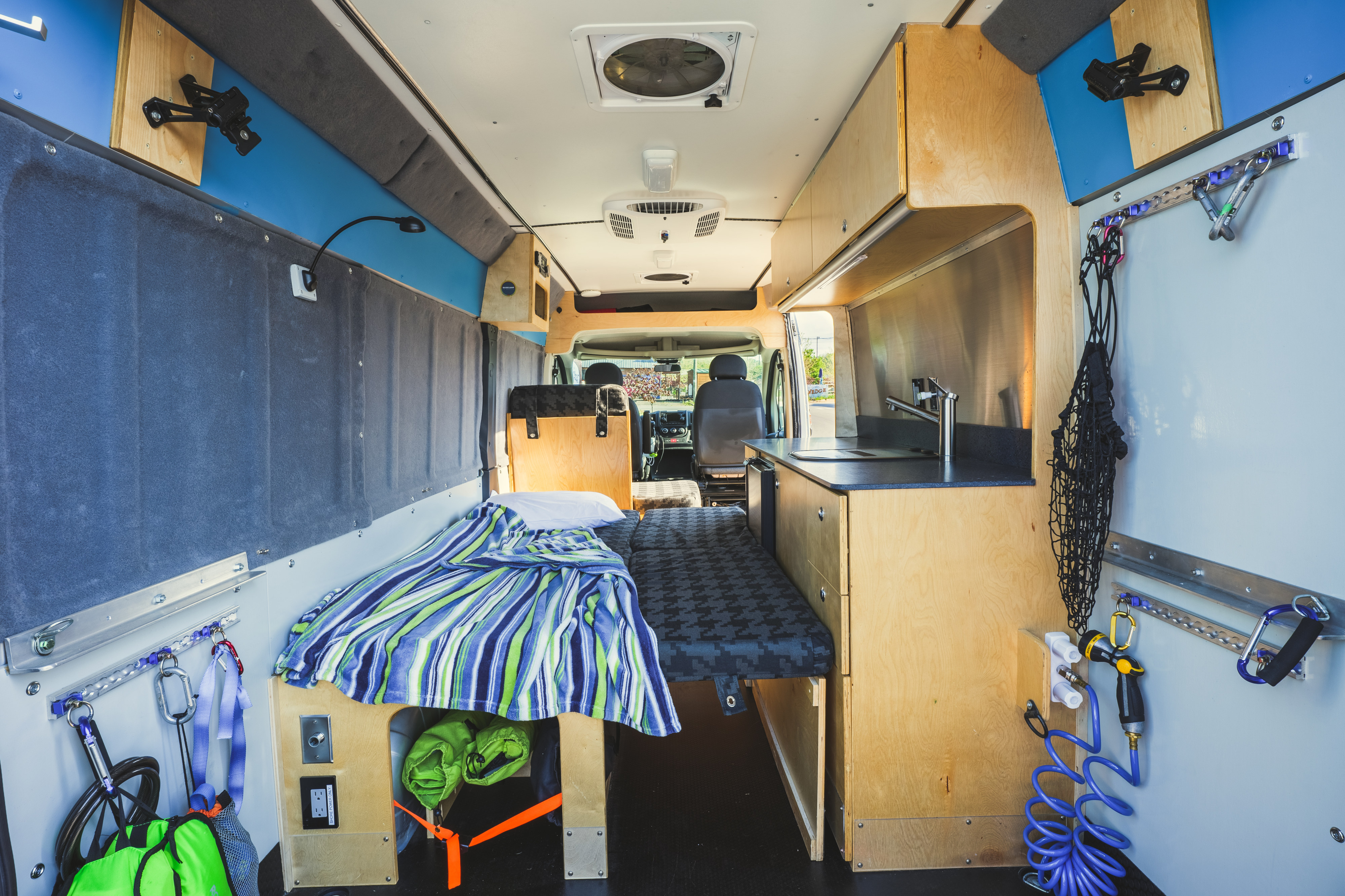 Spacious and functional camper van interior with bed, kitchen, and smart storage, perfect for an rv rental adventure.. Custom Promaster 3500 2015