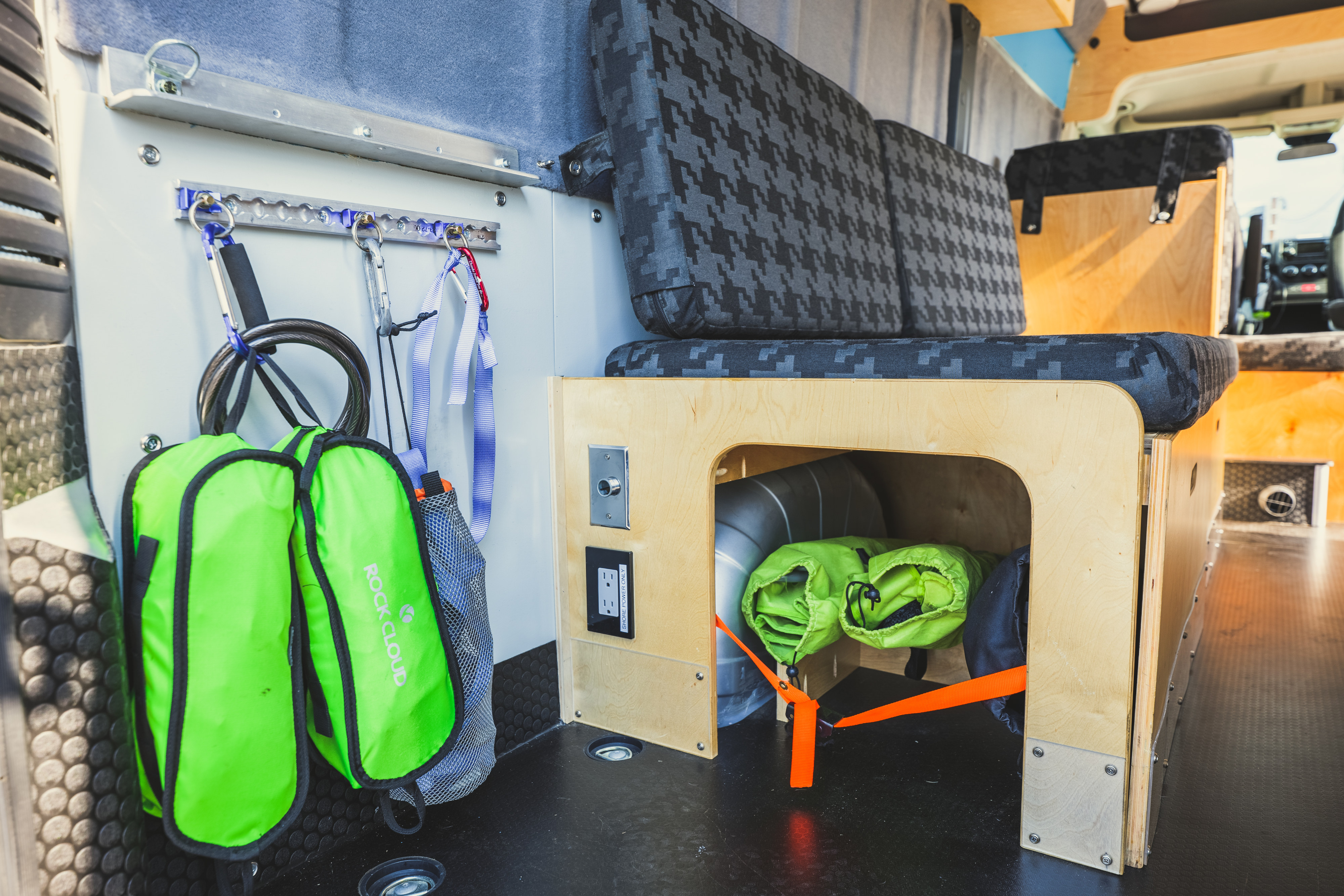 This RV rental shows smart interior organization: hanging gear, under-seat storage, and patterned seating.. Custom Promaster 3500 2015