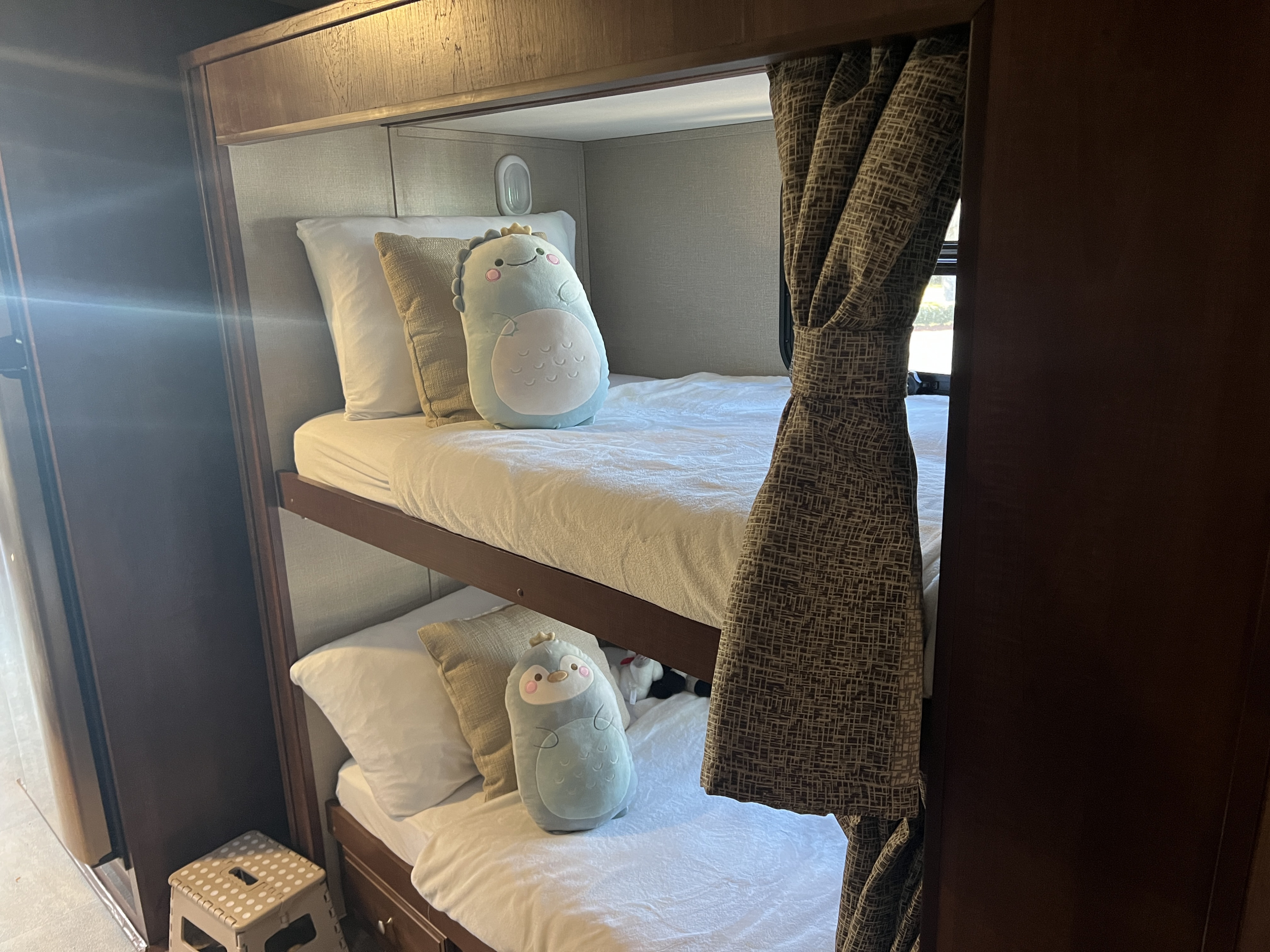 Comfortable RV rental bunk beds, each with soft bedding and unique plush toys, offering cozy sleeping space for travelers.. Forest River 36B5 2017