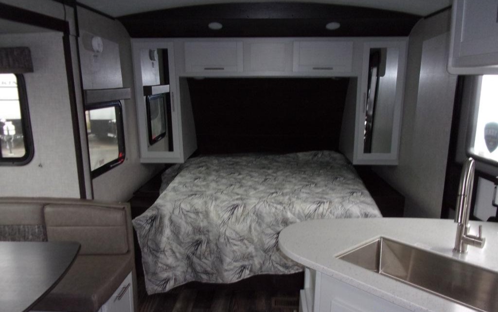 Spacious RV rental interior with a cozy bedroom, modern kitchen, and comfortable dinette, ideal for travel adventures.. Keystone RV Bullet Premier Ultra 2020